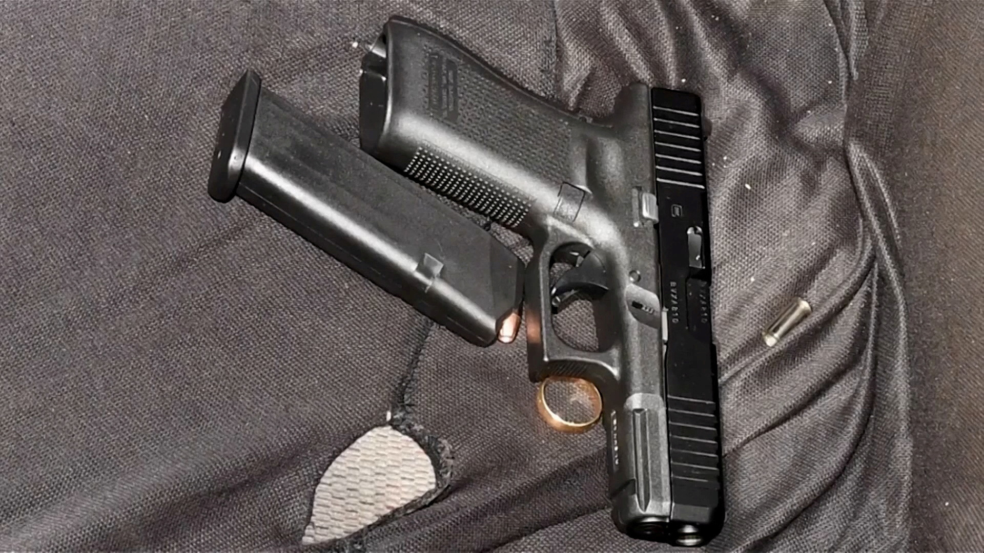A handgun, loaded magazine and a gold ring are seen on the front seat of the vehicle of Black man Jayland Walker, who was shot to death by up to eight officers, in Akron, Ohio, June 27, 2022 in a still image from a police video presentation.