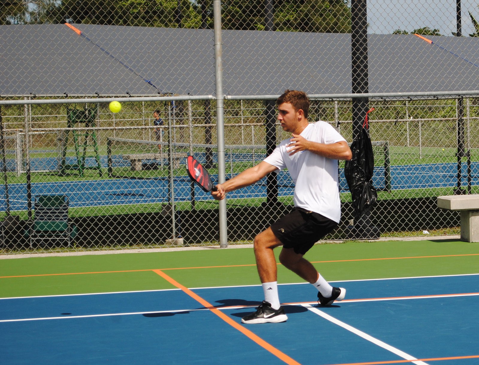 Colin Ramsey connects the return during a pickleball match at the newly striped court at American Memorial Park on Saturday.