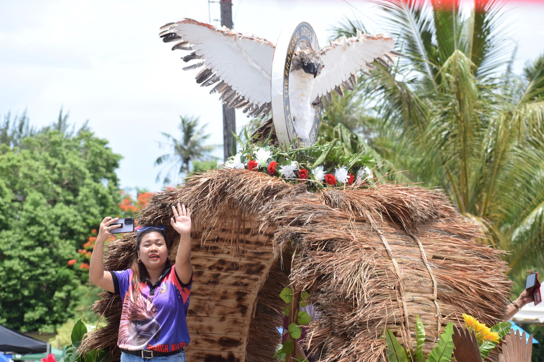 A Magalahi member takes video as she rides the group's float.