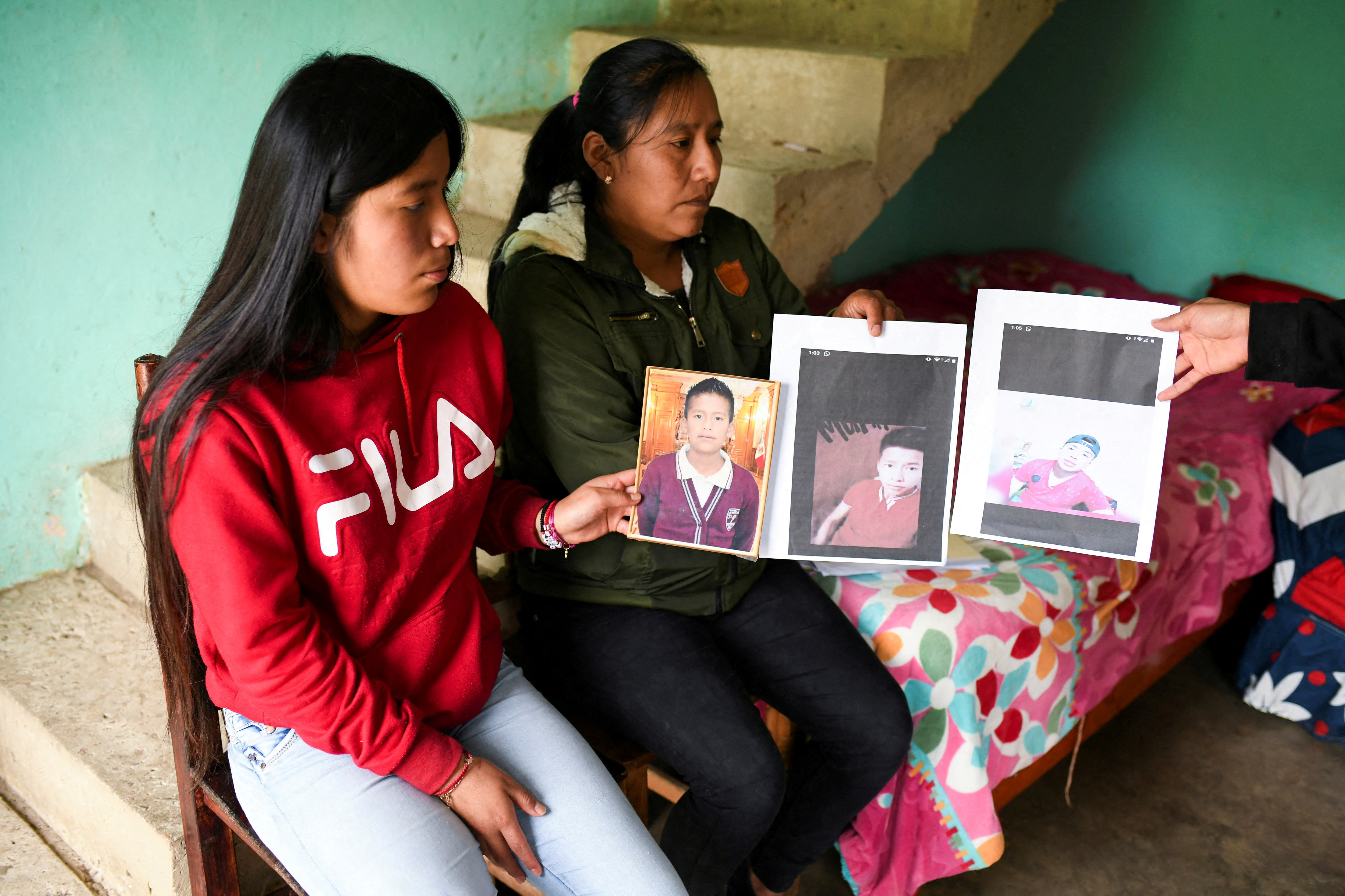 Yolanda Olivares, holds pictures of her sons Jair, 19, Yovani Valencia, 16, and her nephew Misael Olivares, 16, at her house as she believes they were traveling inside the trailer where several migrants died in San Antonio, Texas, in the town of San Marcos Atexquilapan, in Veracruz state, Mexico, June 30, 2022.