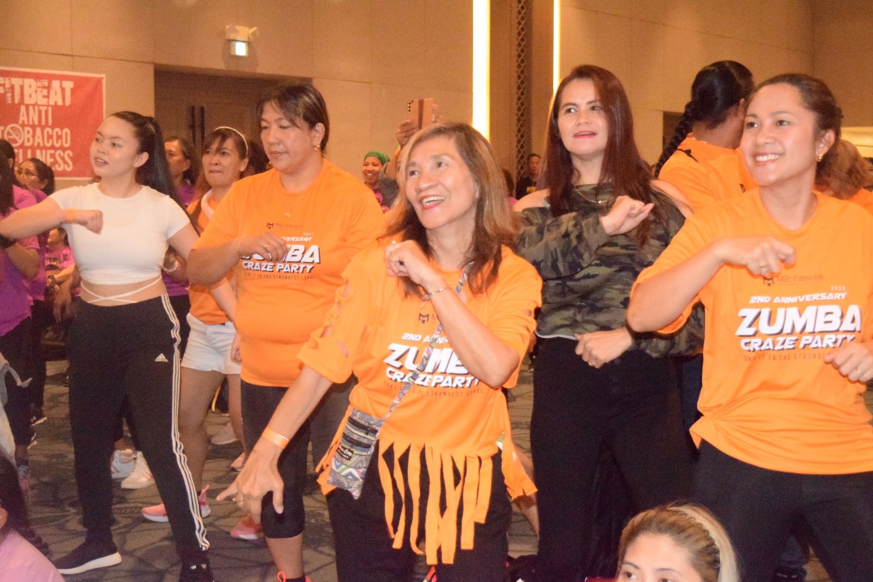 Beth Yamzon, 65,  smiles as she performs Zumba dance moves with other participants.