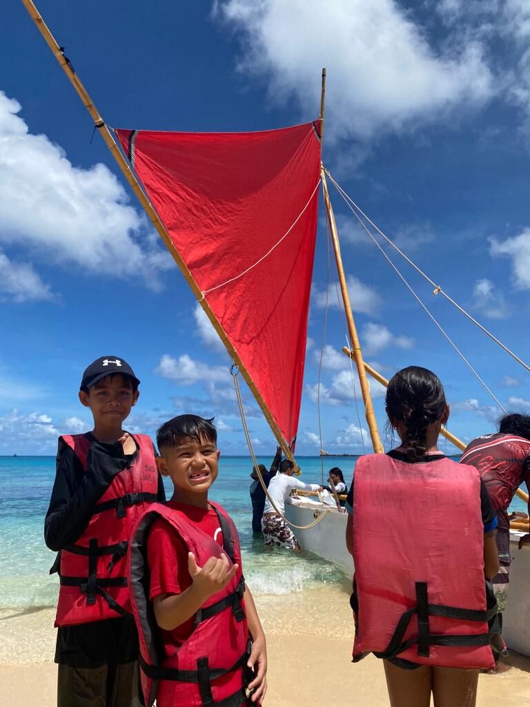 Arturo Rivera, right, and Izaiah Evangelista, left, are all smiles as they wait to board canoe Richard Seman at Tachogna Beach.