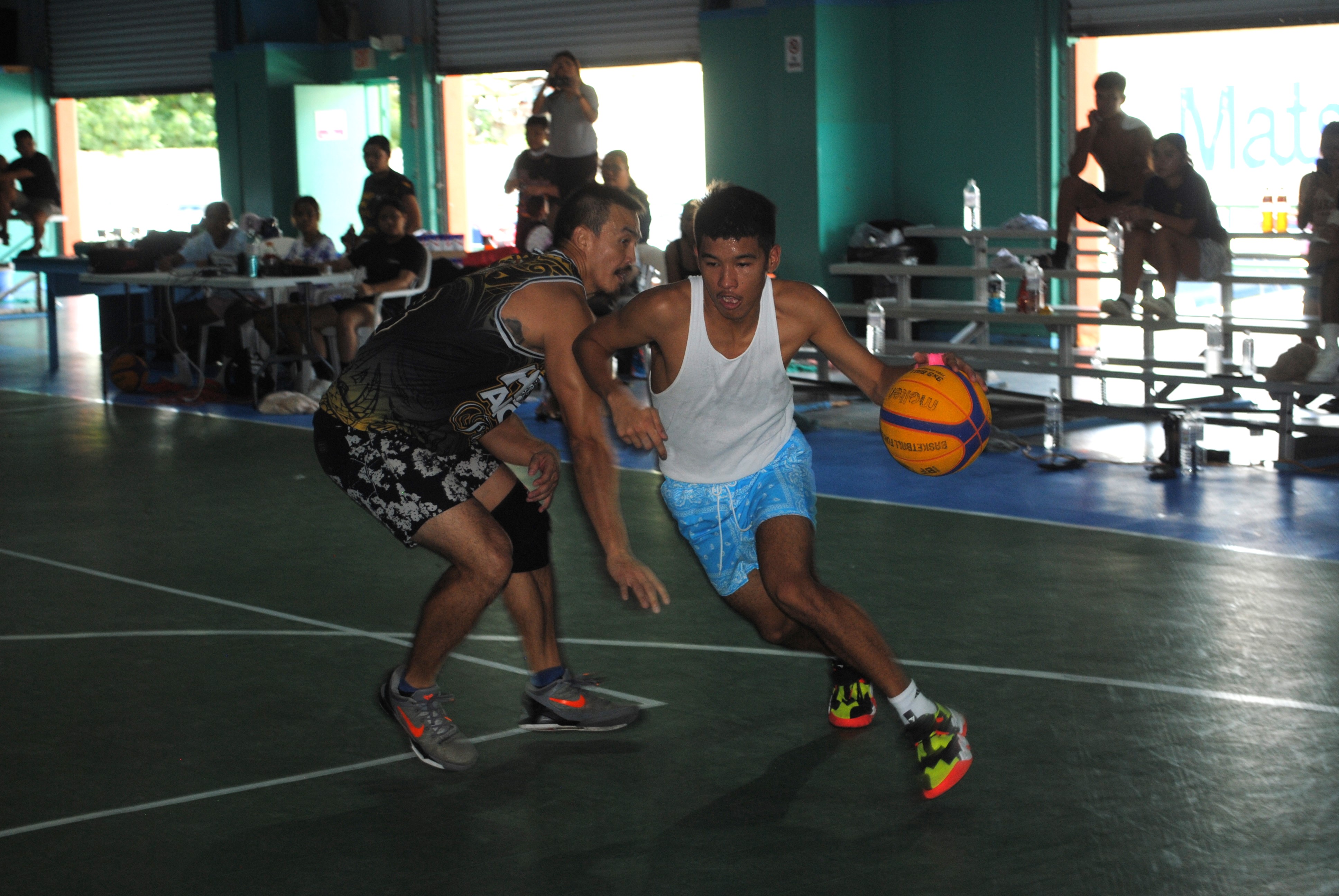 Bench Buddies' Leo Naraja beats Yolo's James Lee for the drive during the finals of the Northern Mariana Islands Basketball Federation’s Three vs Three Hoop Fest Tournament at the TSL Sports Complex on Saturday.