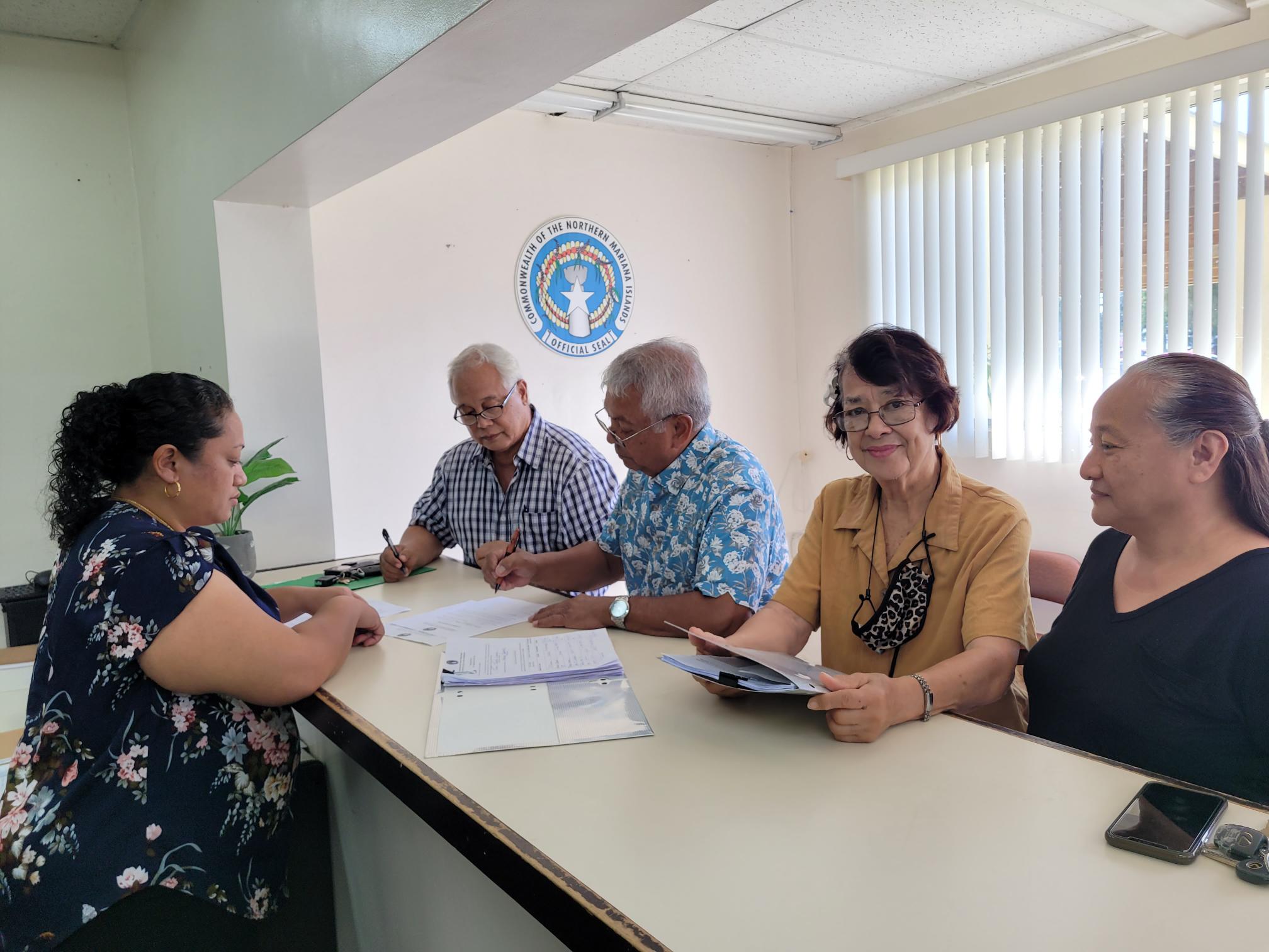 Accompanied by his campaign committee members, former Judge Juan T. Lizama, center, files his candidacy for attorney general on Tuesday afternoon. Also in photo is Commonwealth Election Commission Executive Director Kayla Igitol, left.