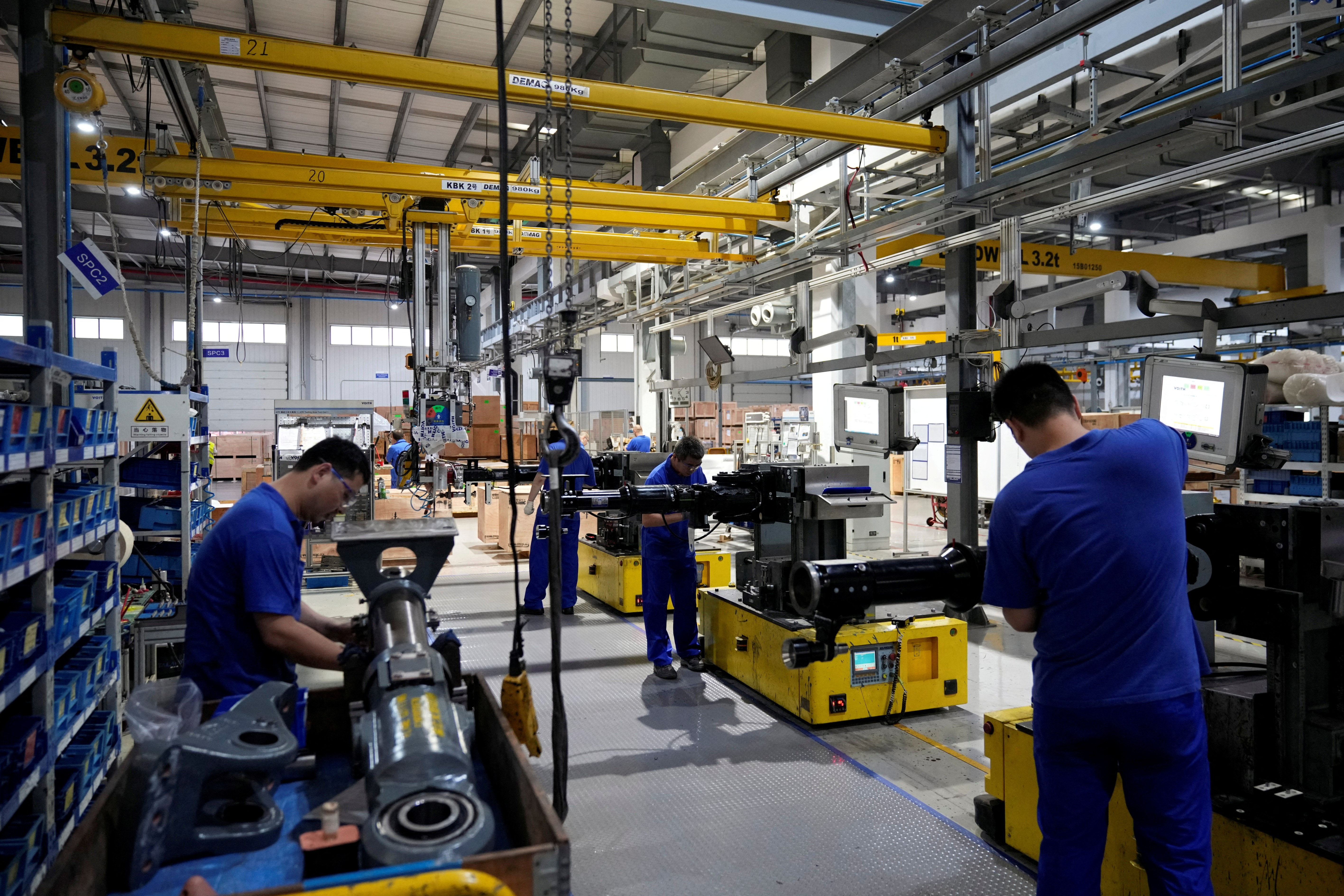 Employees work on the production line of vehicle components during a government-organized media tour to a factory of German engineering group Voith in Shanghai, China on July 21, 2022.