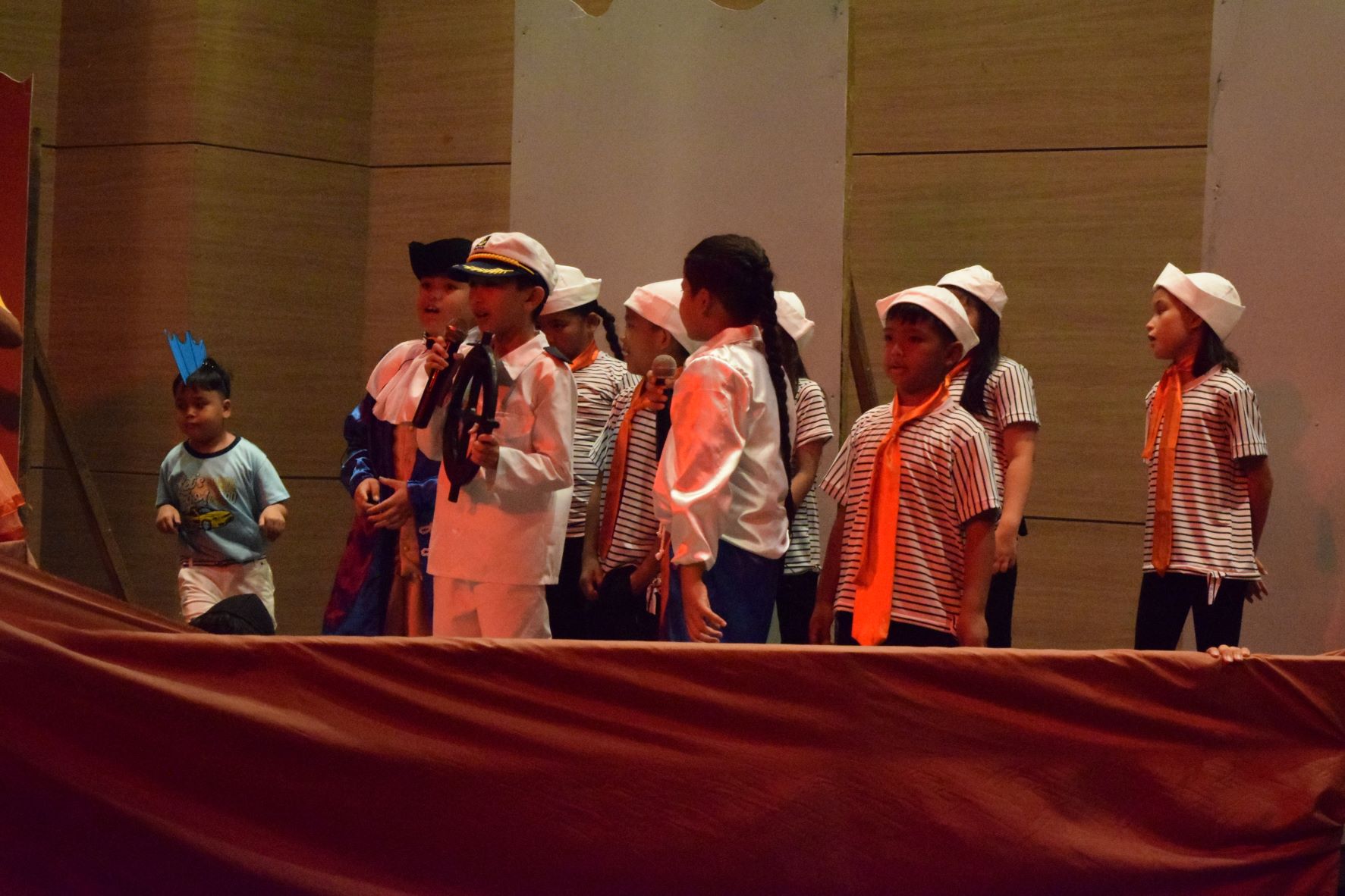 From left, blue-fin fish Liam Buston, Grimmsby played by Paul James Mendoza, Captain played by James Kisa, and Prince Eric played by John Raphael Aguon cruise the sea with sailors Juslynn Mizutani, Jayden Pulido and Kiani Delos Reyes.