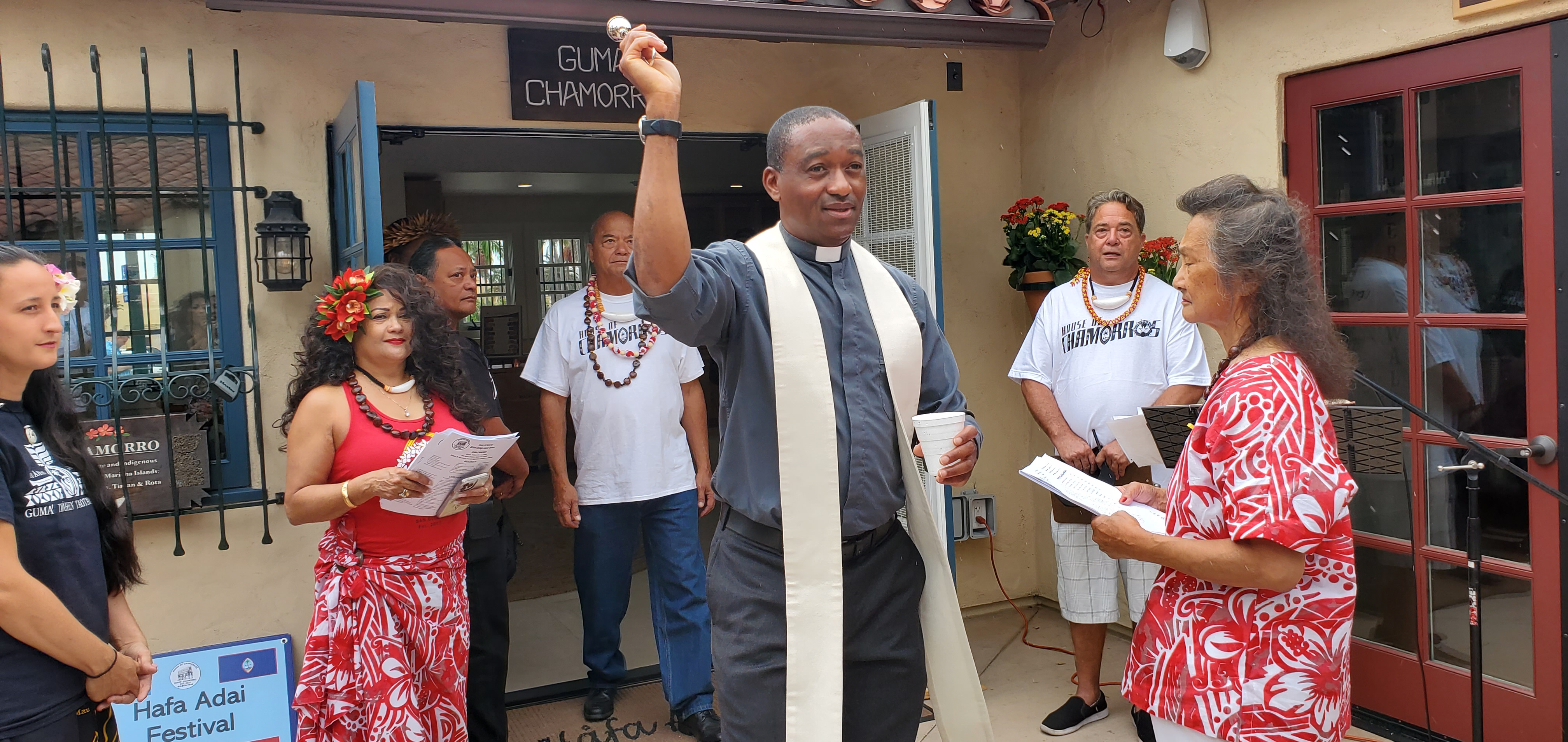 Father Lawrence Agi blesses the guests and HOC Board of Directors member Brenda Maanao Diaz at the House of Chamorros grand opening and Hafa Adai Festival at Balboa Park in San Diego, California Saturday morning while HOC President Jeff Macaraeg, Vice President Philip Gogue Jr., and BOD member Lola Gogue look on.