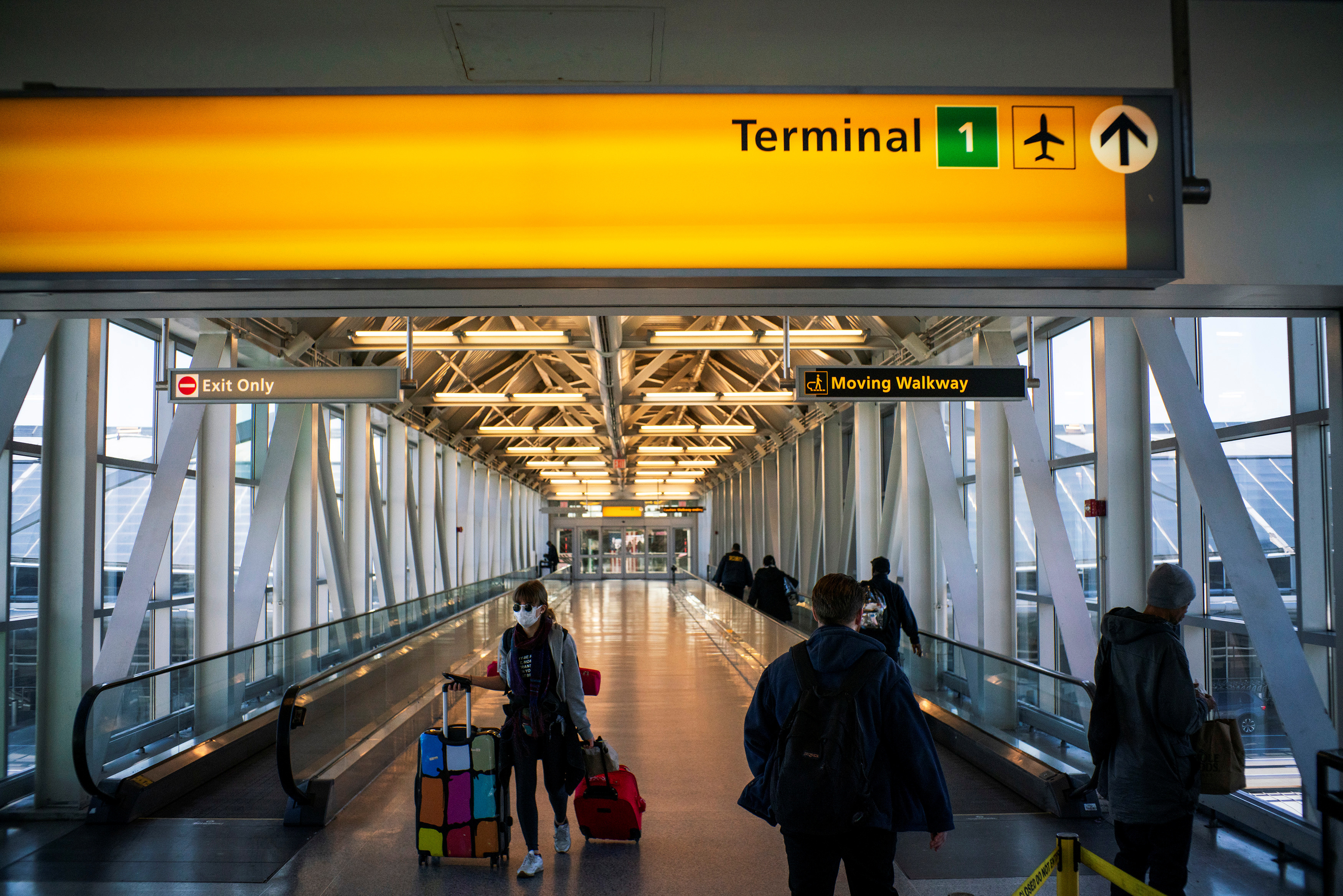 People walk around terminal one at JFK airport after the Federal Aviation Administration  temporarily halted flights arriving at New York City airports due to coronavirus disease in New York, March 21, 2020.