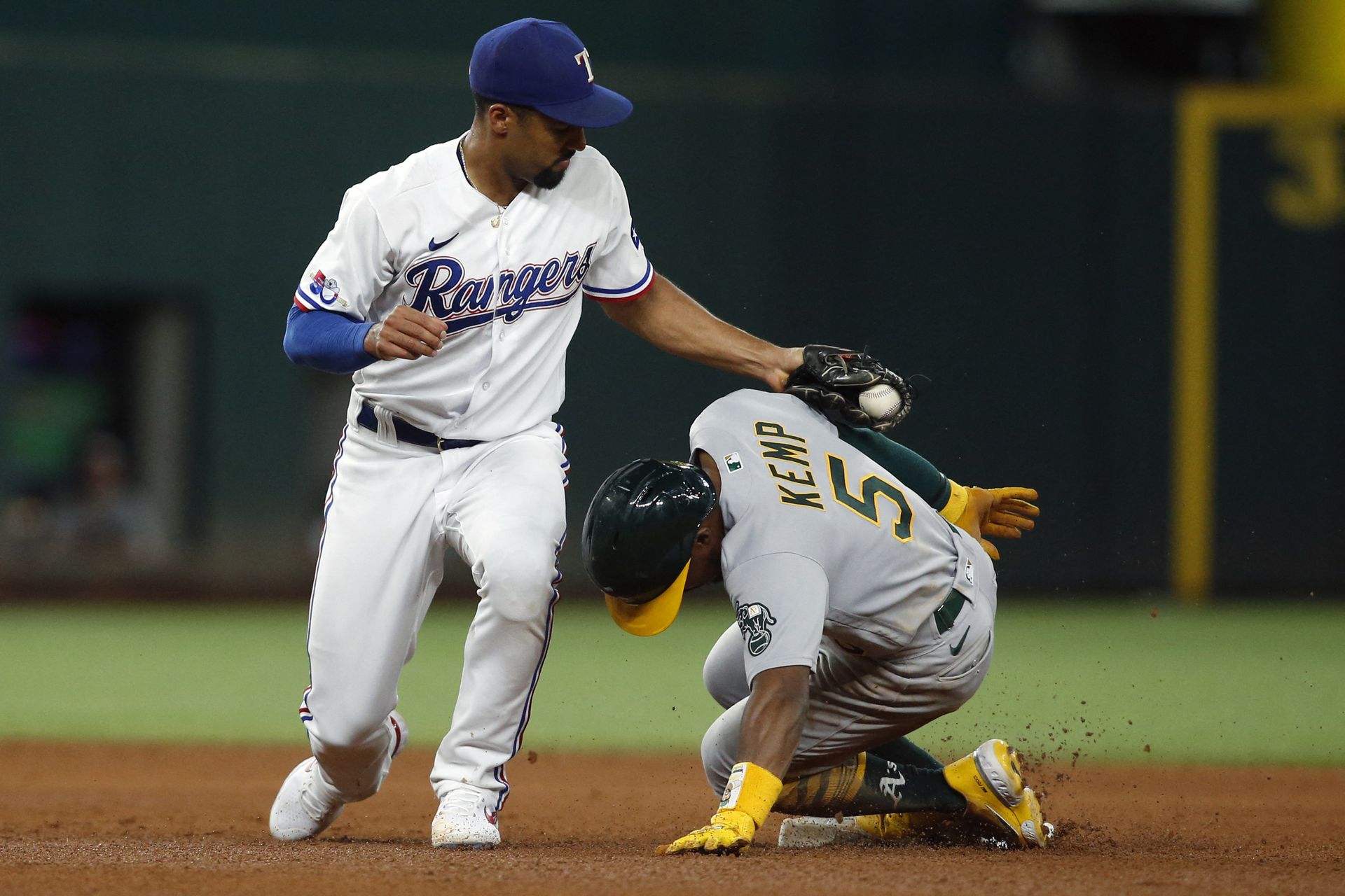 Oakland Athletics left fielder Tony Kemp (5) steals second base in the fifth inning as Texas Rangers second baseman Marcus Semien (2) applies the tag at Globe Life Field in Arlington, Texas, Aug. 15, 2022.