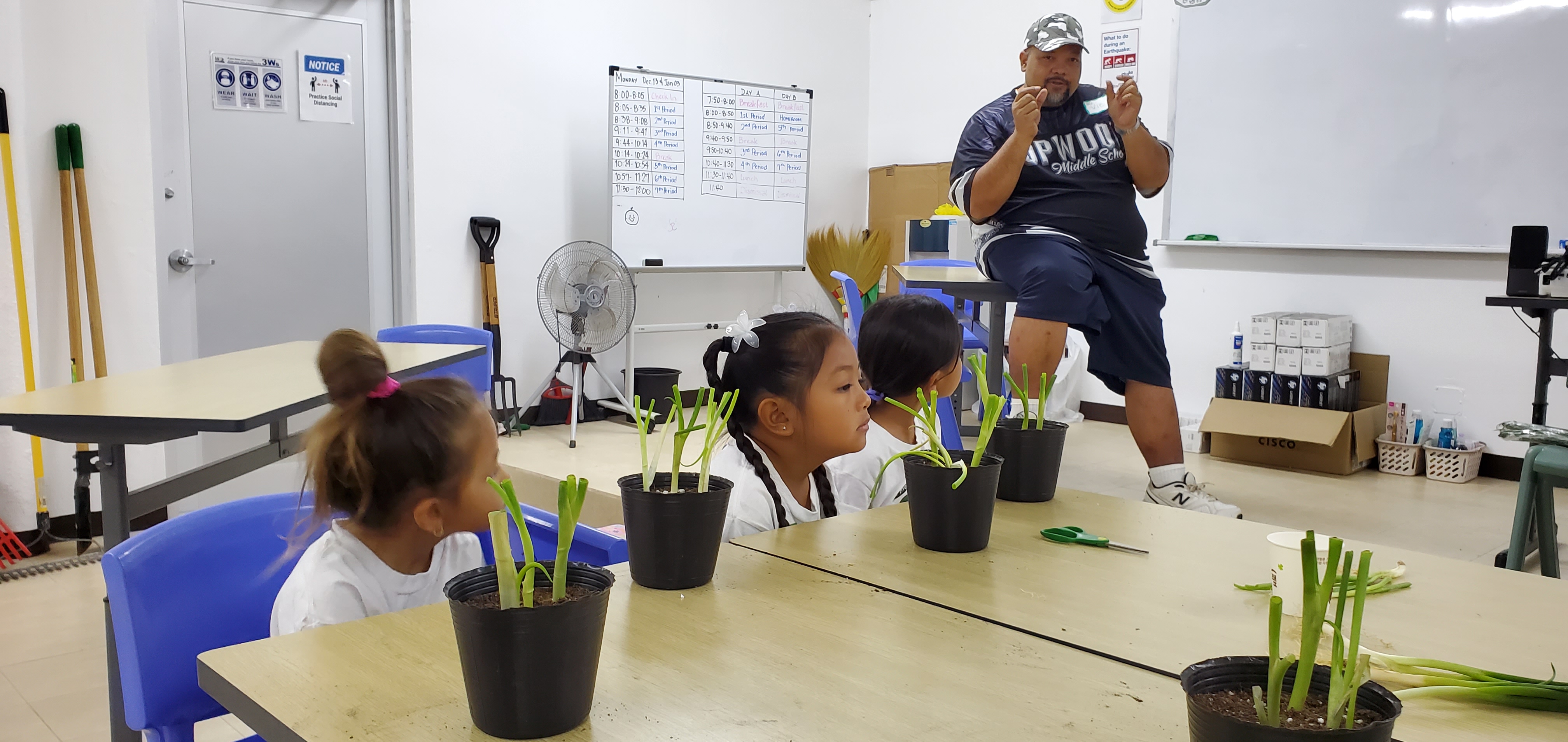 Career Technical Education instructor Victor Cabrera discusses tips on how to best grow green onion sprouts with NMI Girl Scouts Saturday at Hopwood Jr. High School.