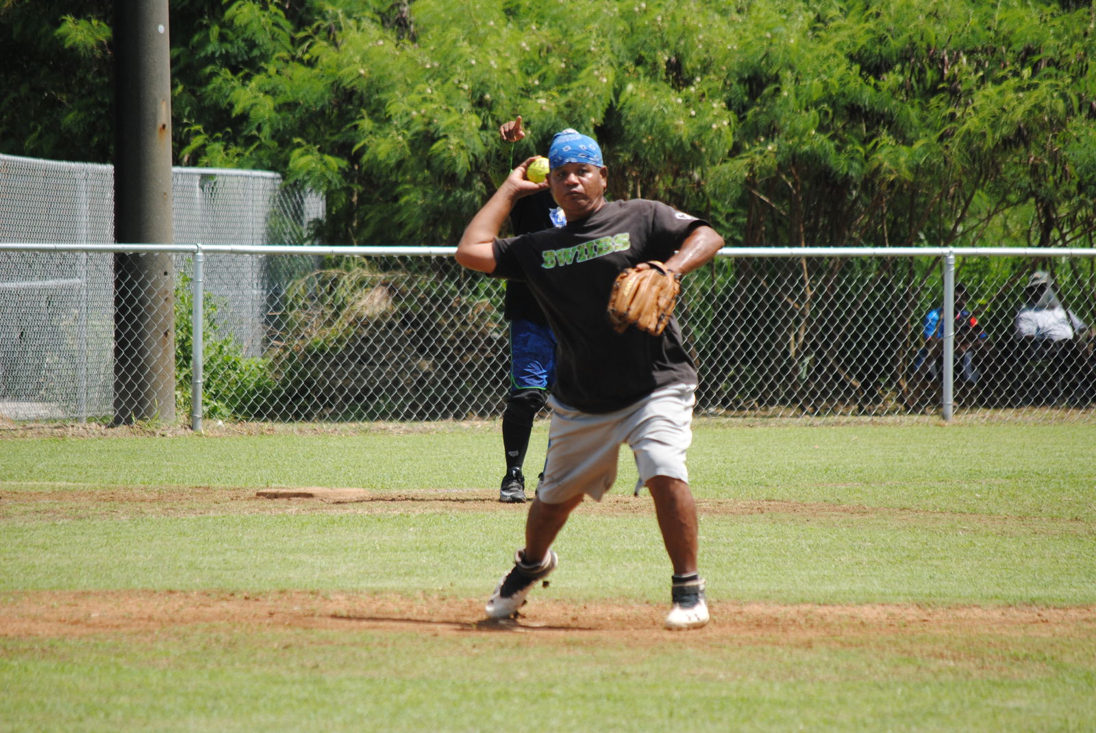 Ameliik's pitcher Ken Kaipat throws to first base for the out during a 2022 Budweiser Belau Amateur Softball League game at the Dandan baseball field.