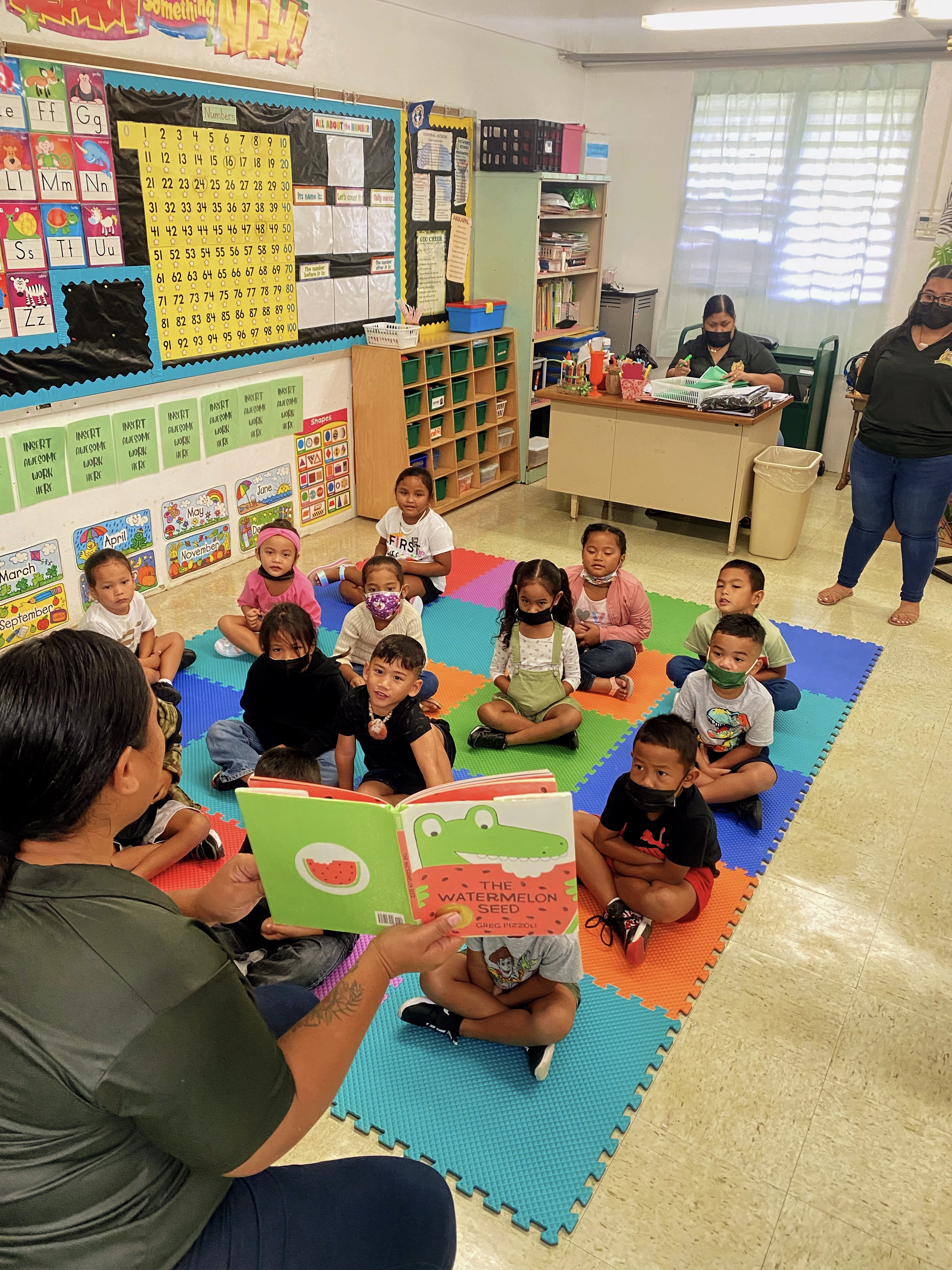 Kindergarten students at GTC Elementary School listen to a story read by their teacher on Monday.