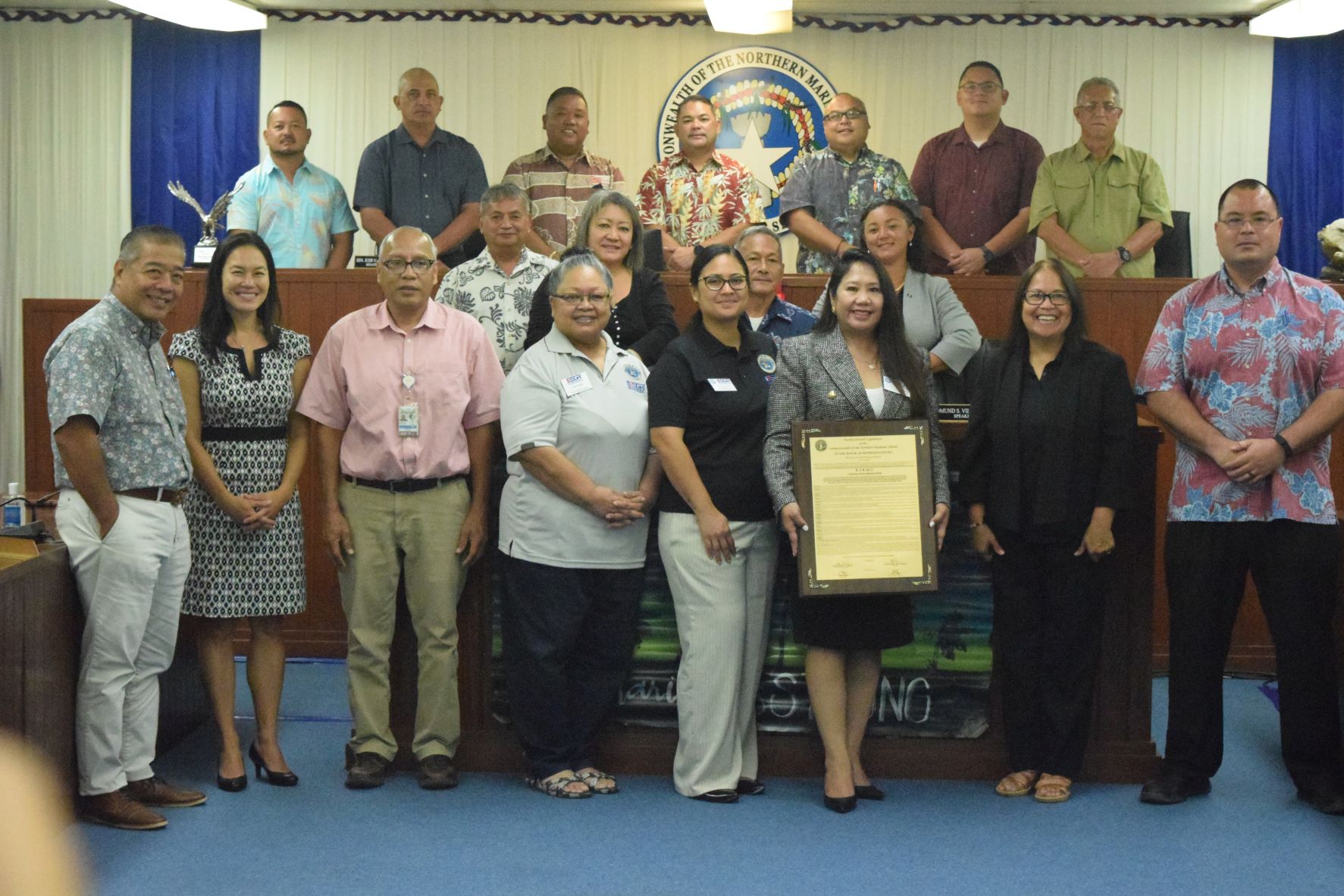 Employer Support of the Guard and Reserve Guam-CNMI ombudsman Joann Aquino, third right, holds the framed copy of House Joint Resolution 22-17 as she, ESGR Guam-CNMI Area Chair Rita A. Sablan, Ed.D., second right, Employer Outreach Coordinator Rose Igitol, fourth left, ESGR volunteer Joshlyn Blas and Commonwealth Healthcare Corp. purchasing manager Patrick Cabrera, third left, pose for a photo with the resolution's author, Speaker Edmund Villagomez, other members of the 22nd Legislature and Saipan and Northern Islands Municipal Council Chairman Danny Aquino, left.
