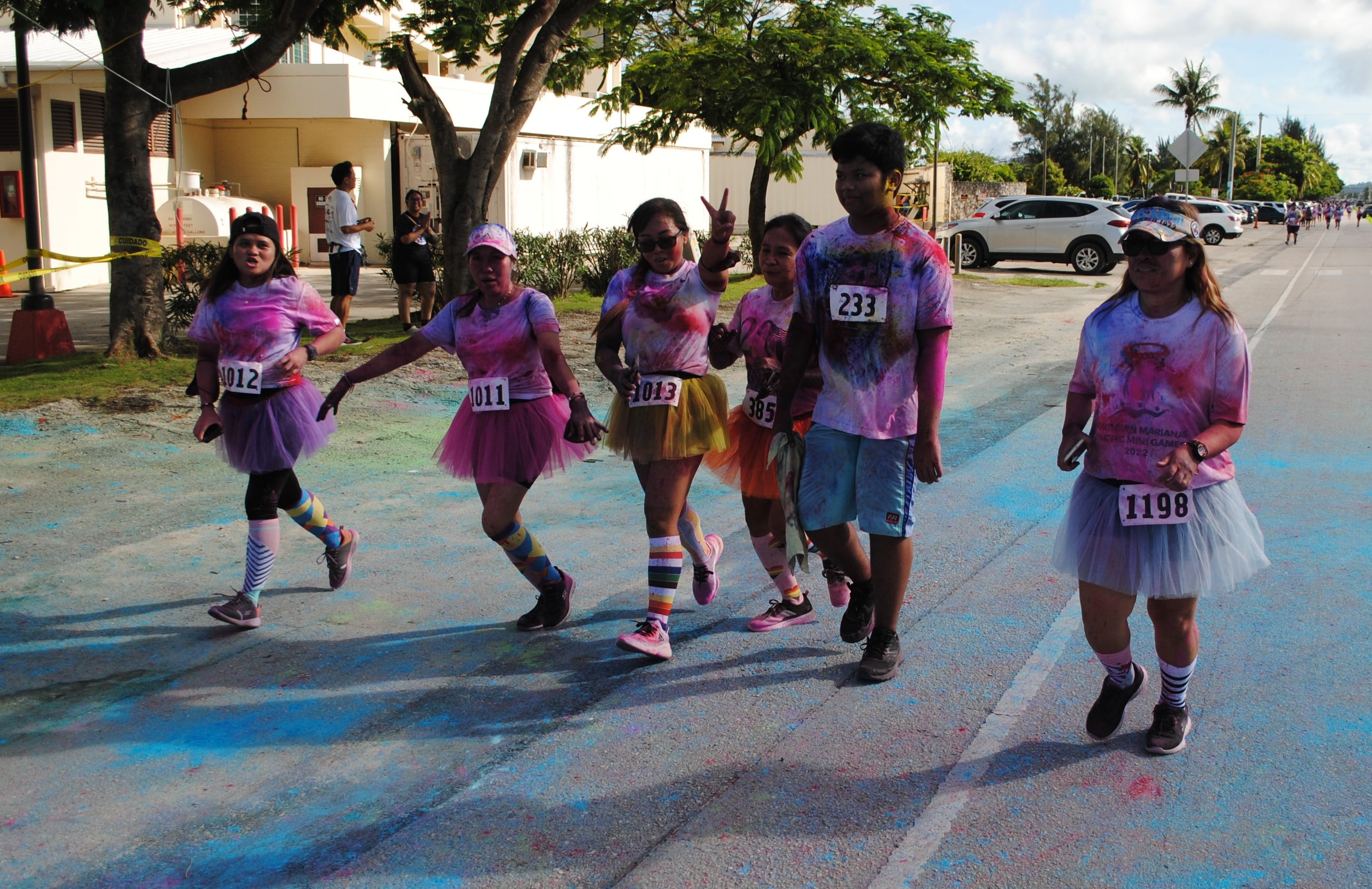 A group of colored participants celebrate as they cross the finish line.