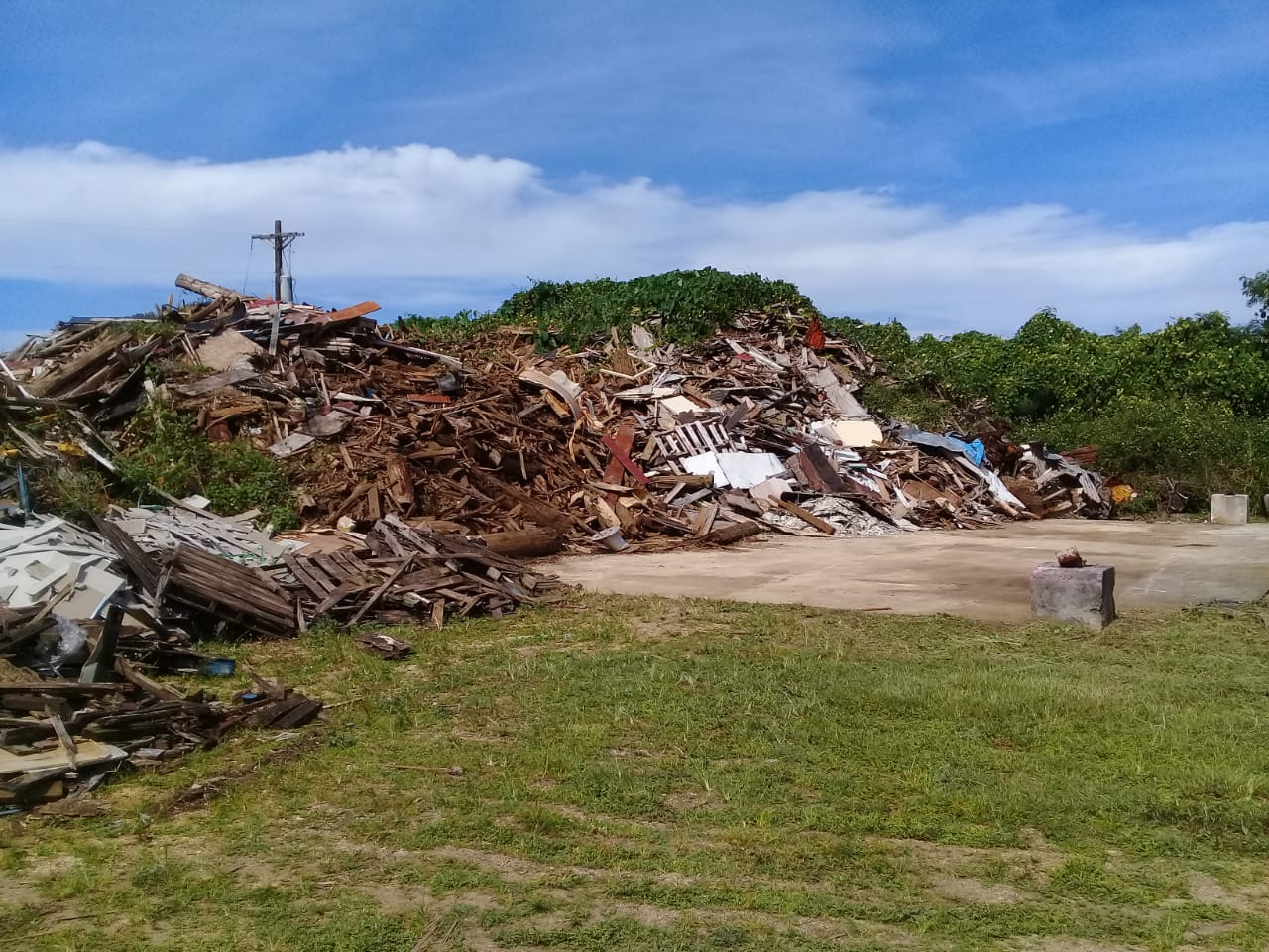 A Jan. 20, 2022 file photo of a portion of the super typhoon waste and debris site on Tinian. Pictured are 15 to 20-foot piles of scrap wood that was collected on Tinian following 2018’s Super Typhoon Yutu. The site was closed off to the public in Feb. 2022. On or around June 19, 2022, a fire occurred on Tinian that eventually grew and made its way to the site. Burned materials at the site included tires, wood, and other debris, raising concerns of toxic materials spreading in the air and soil.