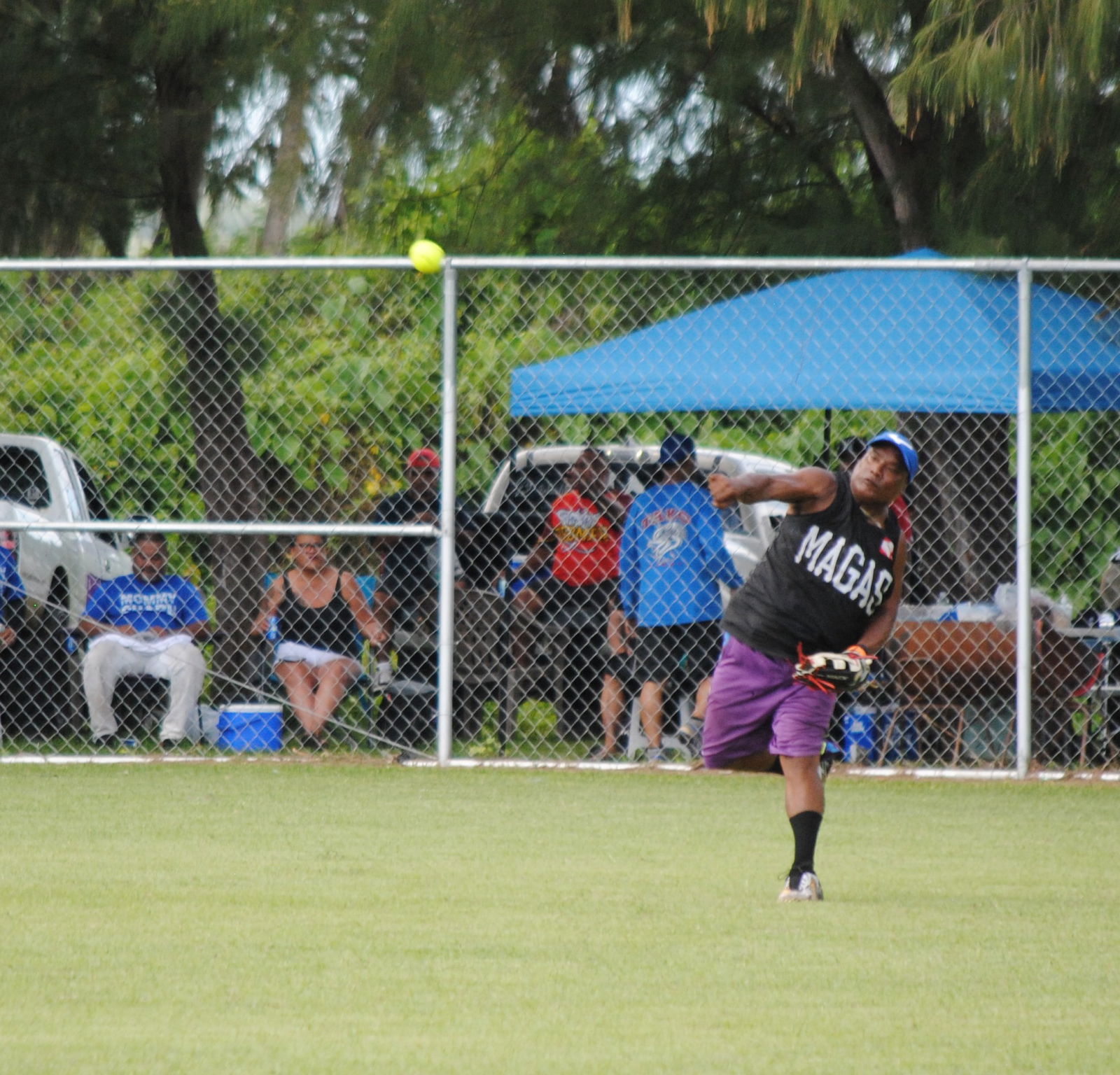 Asahi's centerfielder Ito throws the ball infield during a 2022 Budweiser Belau Amateur Softball League game at the Dandan baseball field.