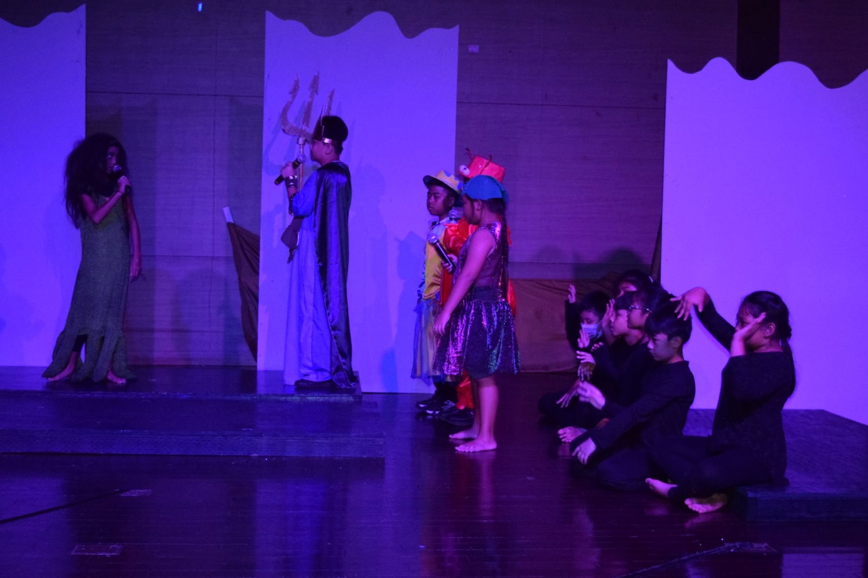 Ursula is confronted by King Triton while Flounder, Ariel, Sebastian Flotsam and Jetsom played by Sofia Hernandez look on. Behind them are Ursula's tentacles played by the fourth graders.