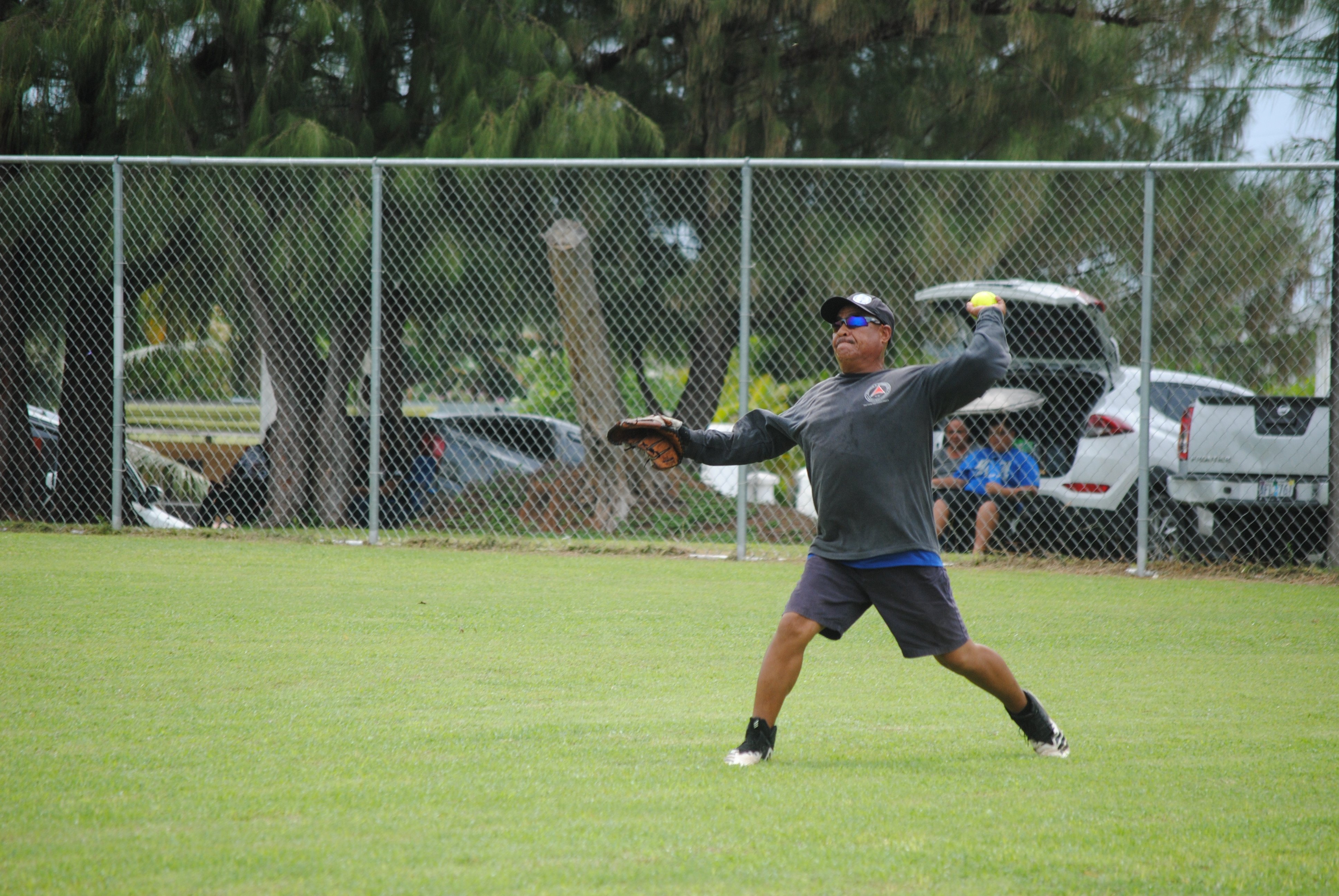 Asahi's right fielder Ray Borja extends for the third to infield during a  2022 Budweiser Belau Amateur Softball League game at the Dandan baseball field.