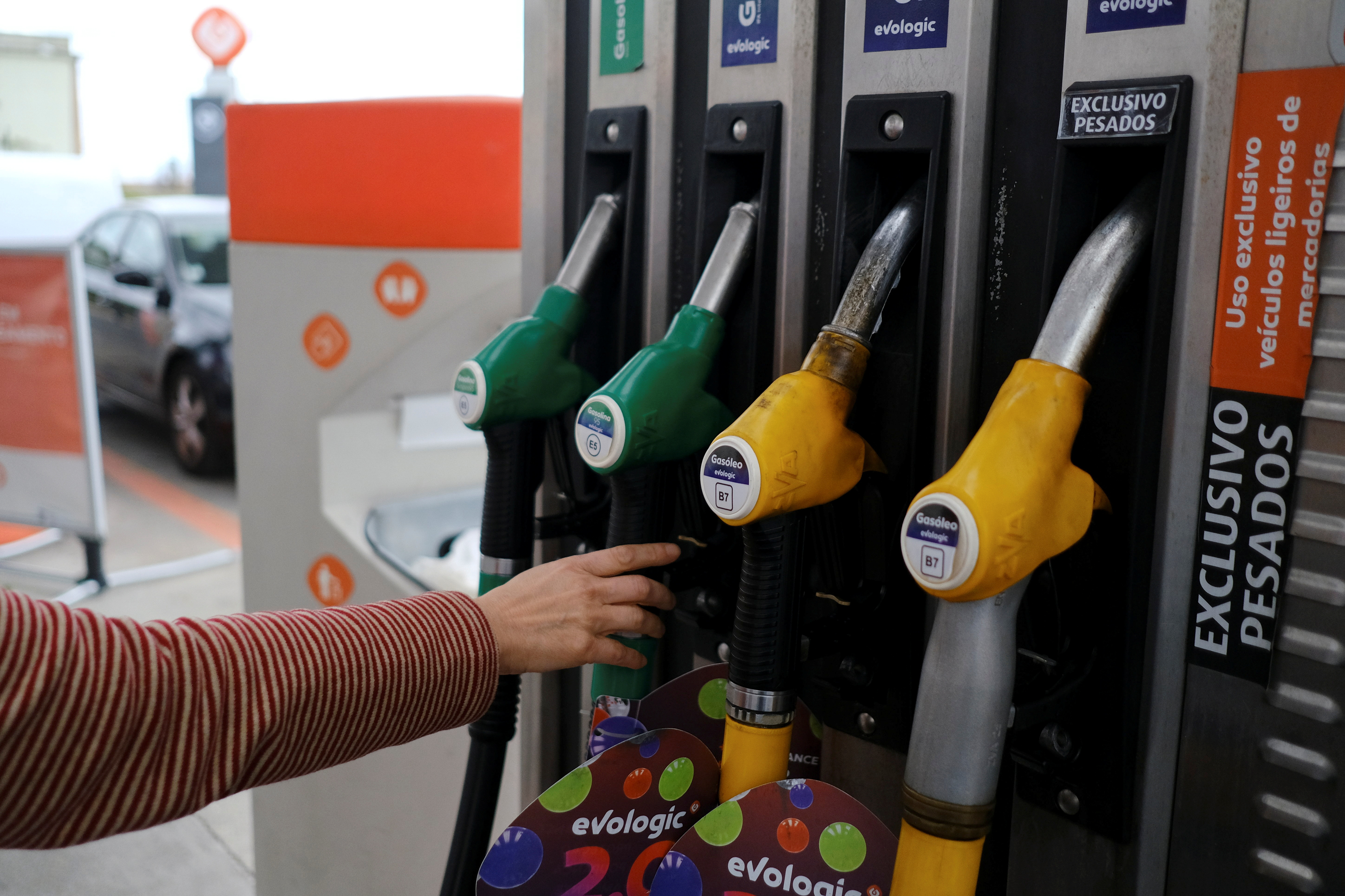 A person uses a petrol pump, as the price of petrol rises, in Lisbon, Portugal, March 7, 2022.