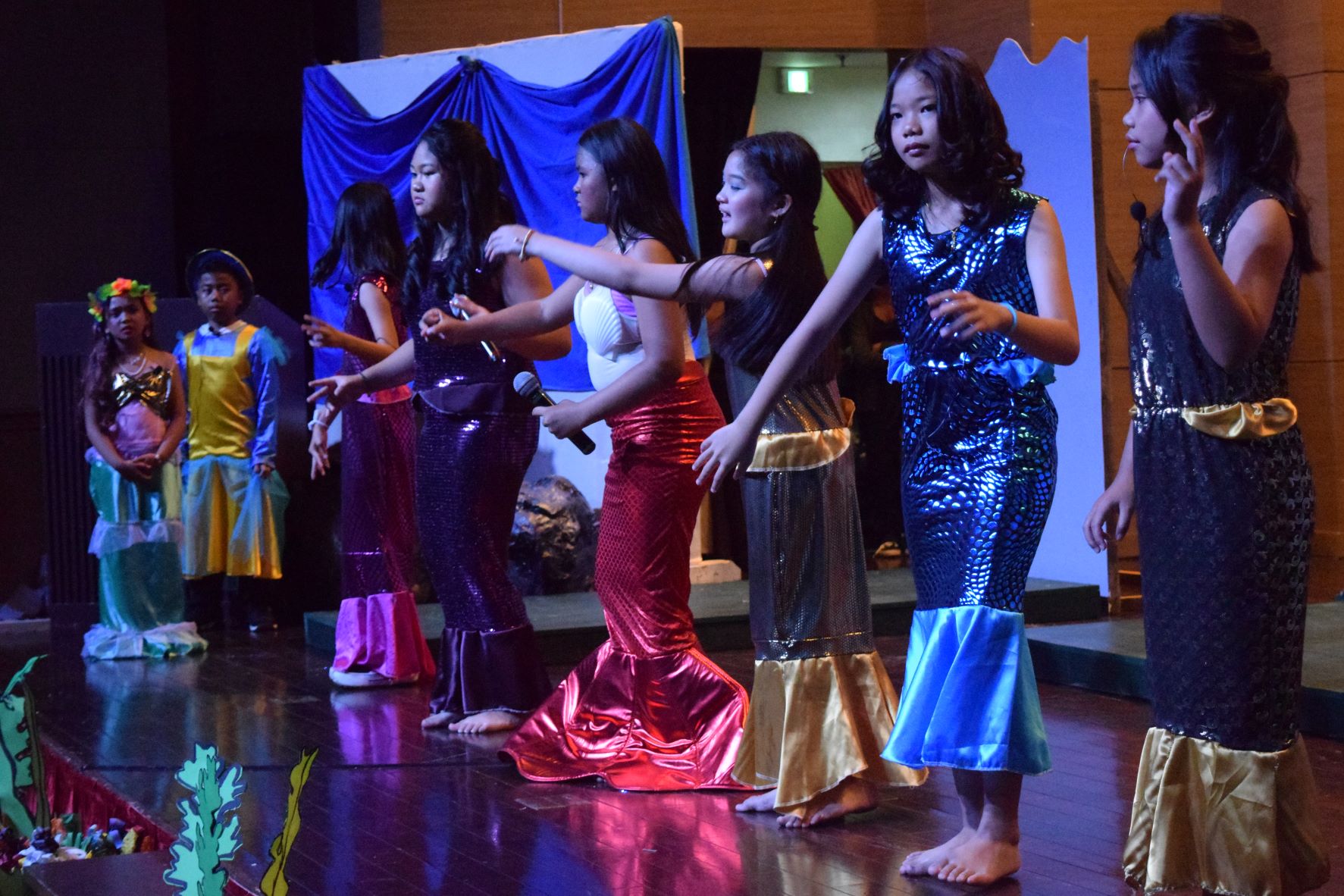 Ariel's sisters perform as Ariel and Flounder watch.
