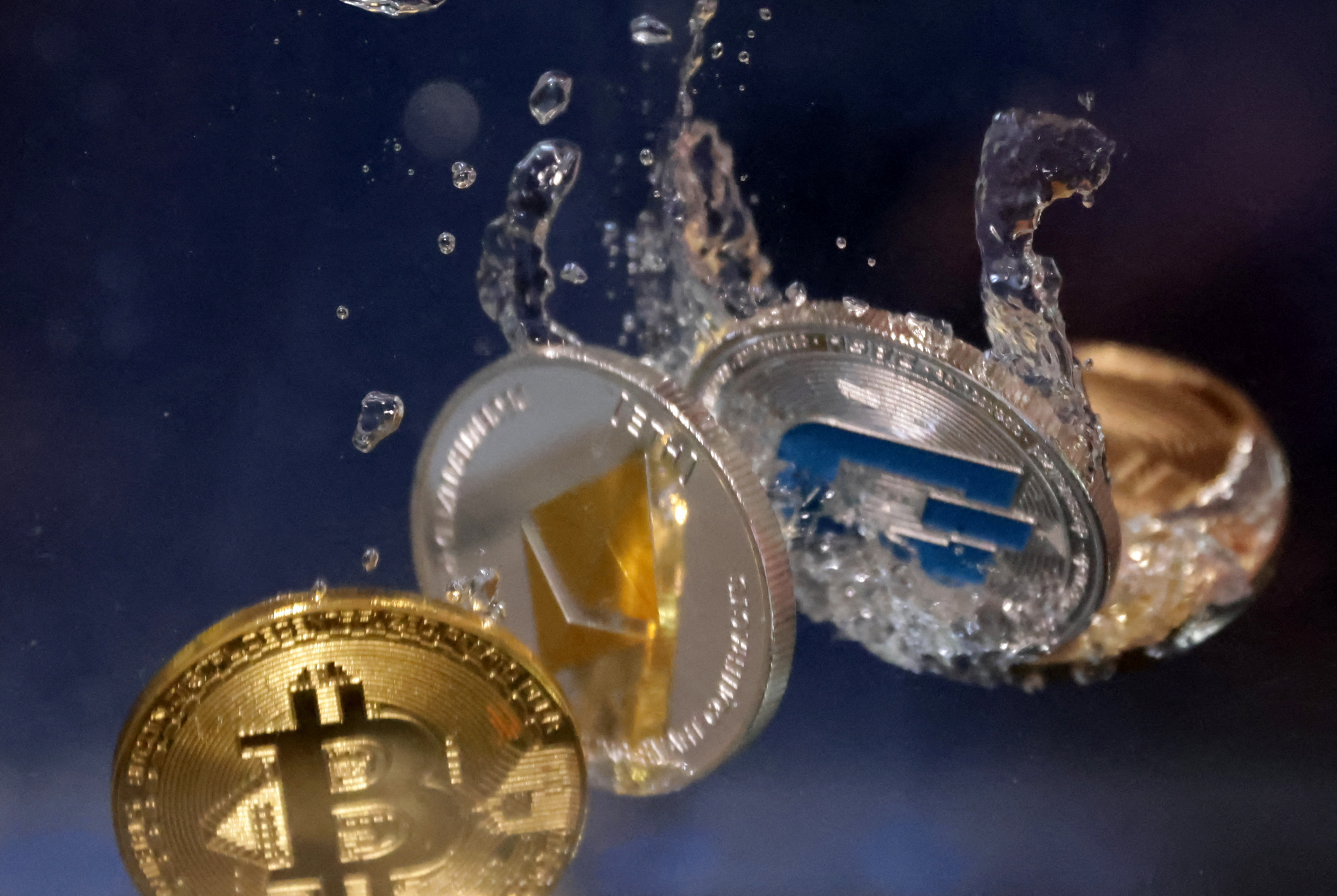 Representations of cryptocurrency Bitcoin, Ethereum and Dash plunge into water in this illustration taken on May 23, 2022.