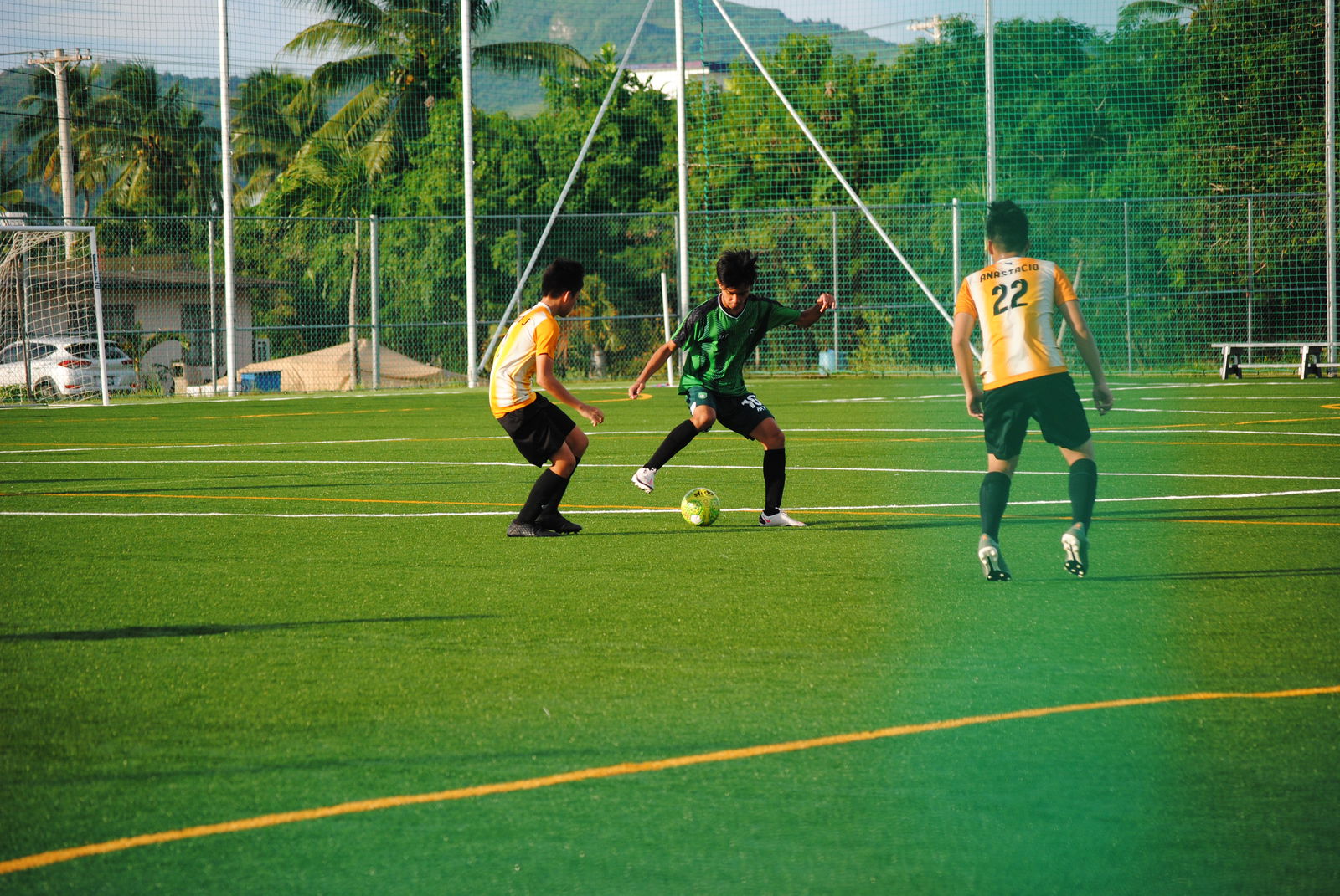 Tan Holdings’ Mark Costales protects the possession as two Kanoa defenders close in.