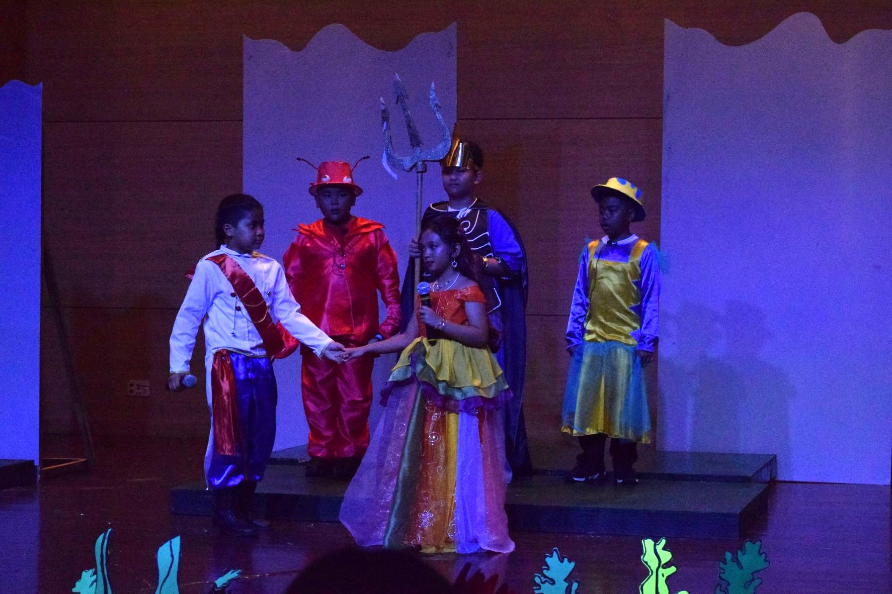 Prince Eric holds Ariel's hand as they leave the throne. Behind them are Sebastian, King Trion and Flounder.