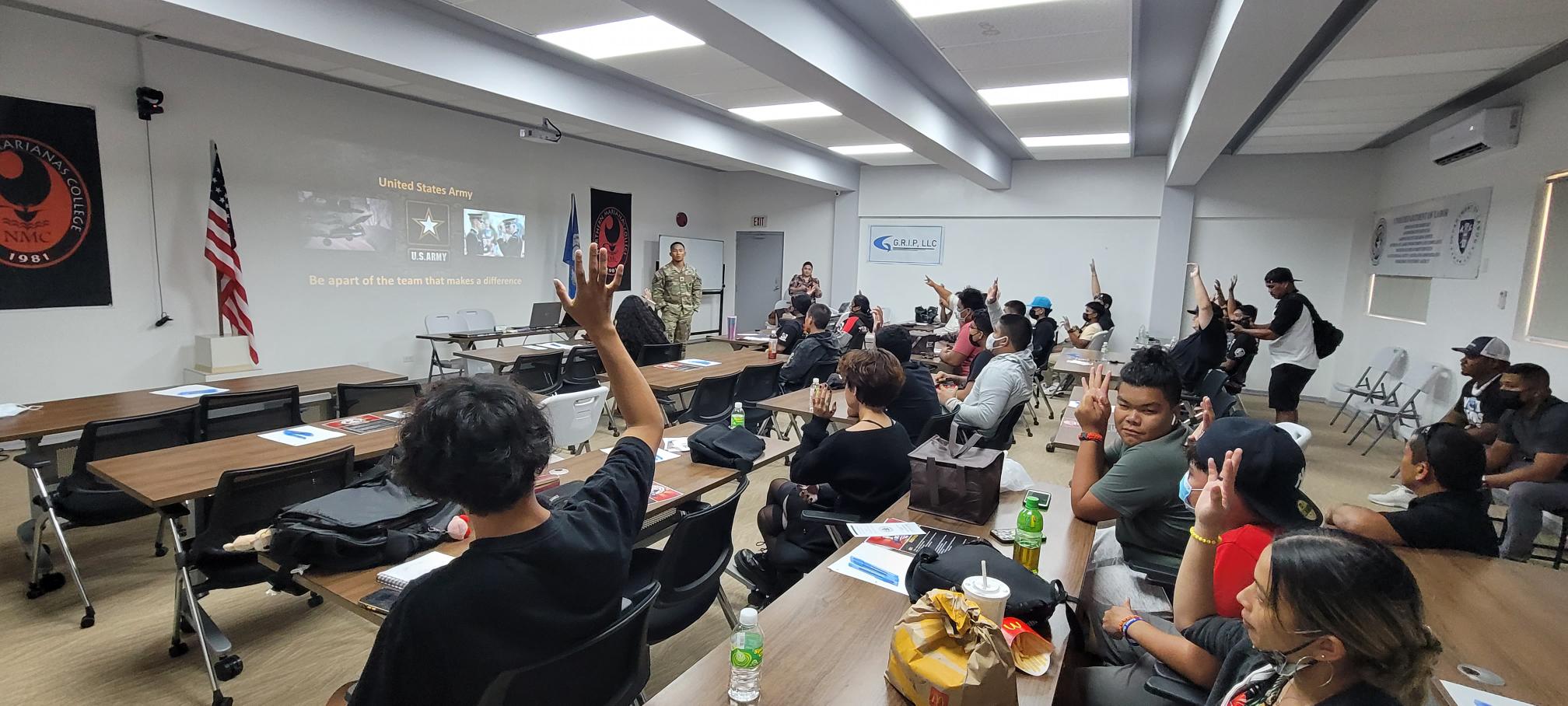 High school students participating in the BOOST Workforce Development Training raise their hands on Friday in response to a question posed by one of the presenters.