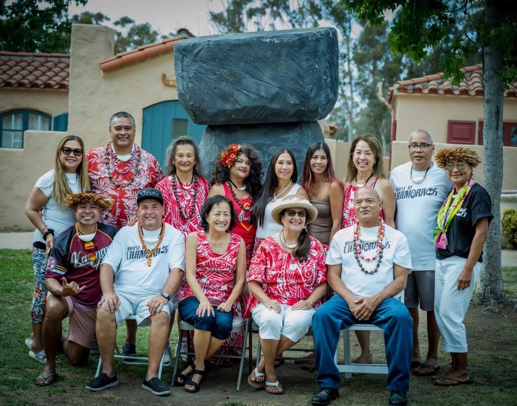 House of Chamorros Executive Board Members and Leadership Team responsible for the successful grand opening of Guma Chamorro take a moment for a photo before the Latte Stone icon at the Hafa Adai Festival in San Diego.
