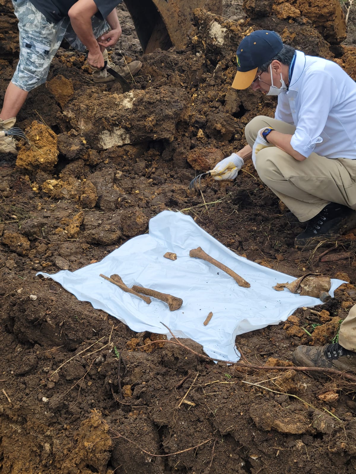 Human bones and a water canteen are placed on a white cloth after they were dug up in Tanapag by officials of the Japan Association for the Collection and Repatriation of Remains of the War Dead with assistance from the CNMI Historical Preservation Office.