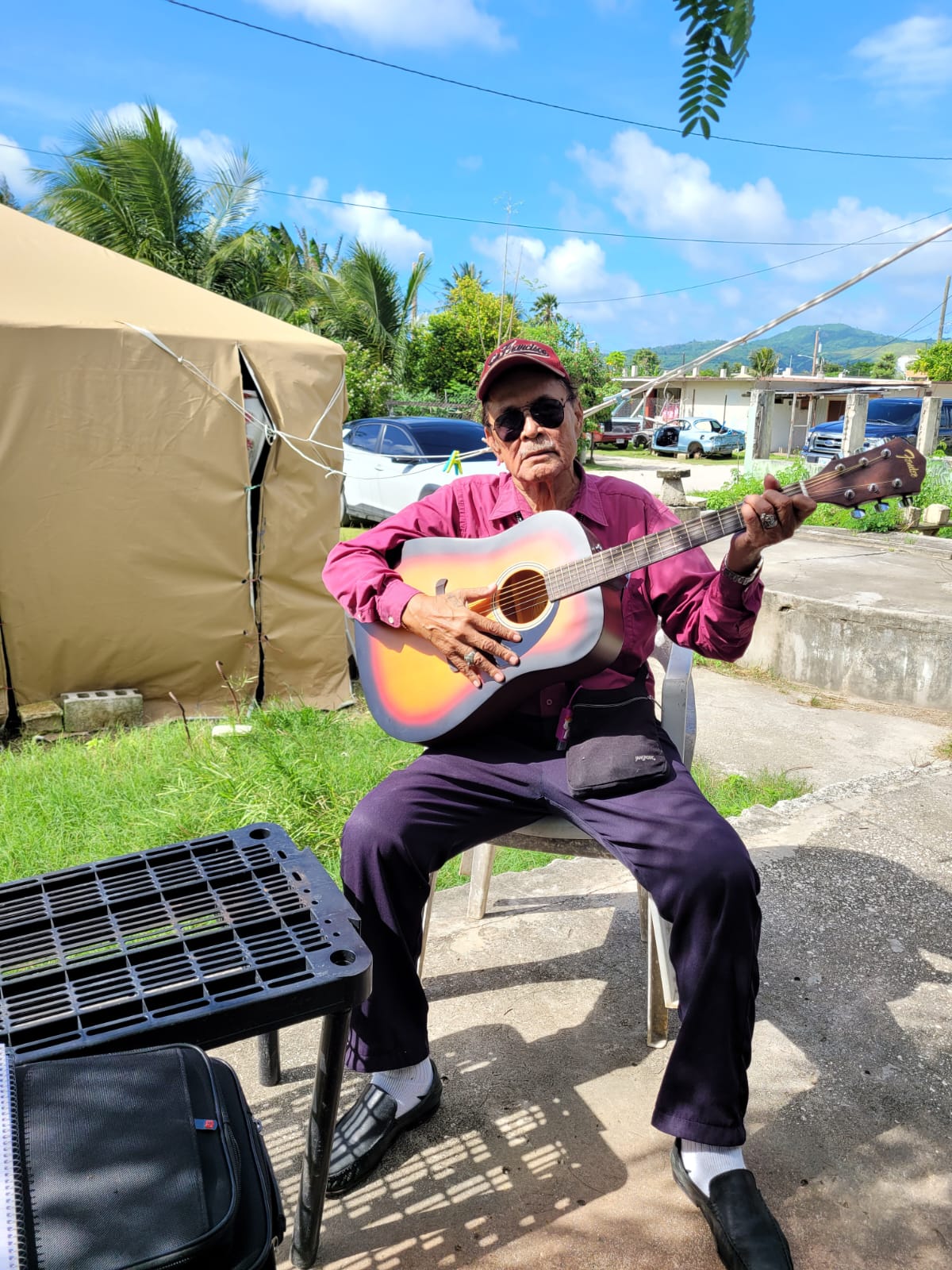 Vicente "Ben" Sablan Basa holds his new Fender acoustic guitar near his tent in Chalan Kanoa.