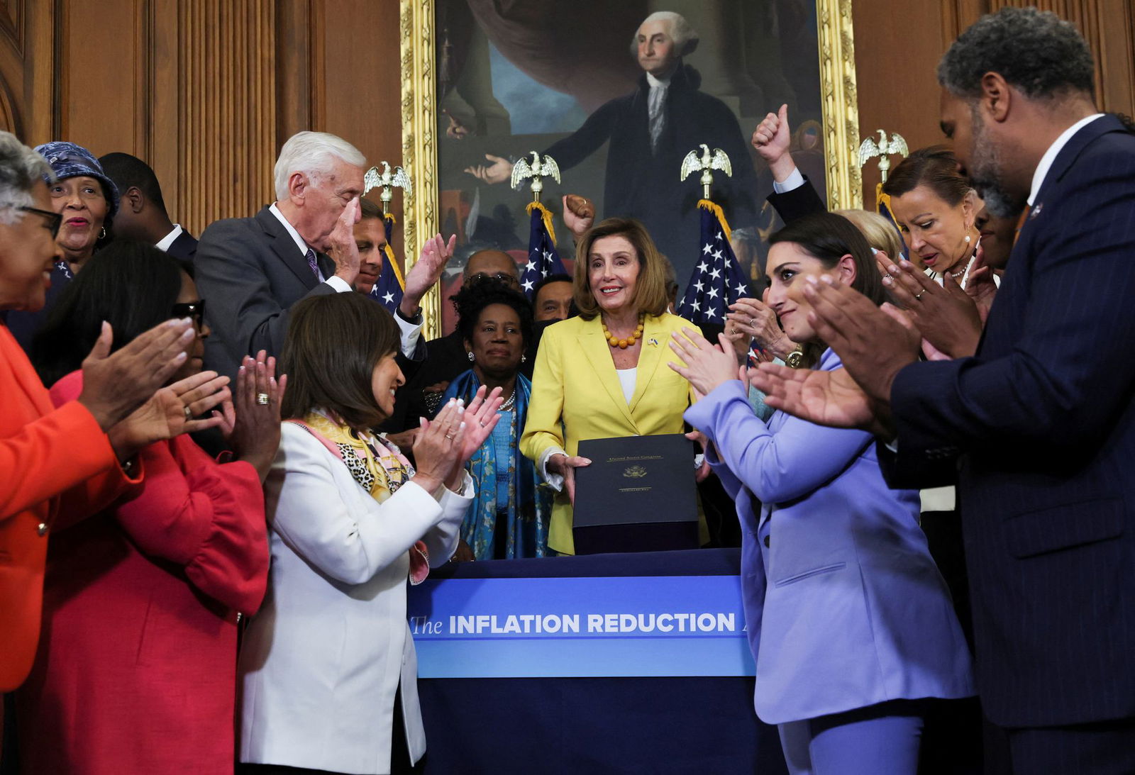 Speaker of the House Nancy Pelosi celebrates with House Majority Leader Steny Hoyer, D-Md., and other Democrats as she holds a signed copy of H.R. 6376, the "Inflation Reduction Act of 2022," at an enrollment ceremony after the bill passed the House on Capitol Hill in Washington, D.C., Aug. 12, 2022.