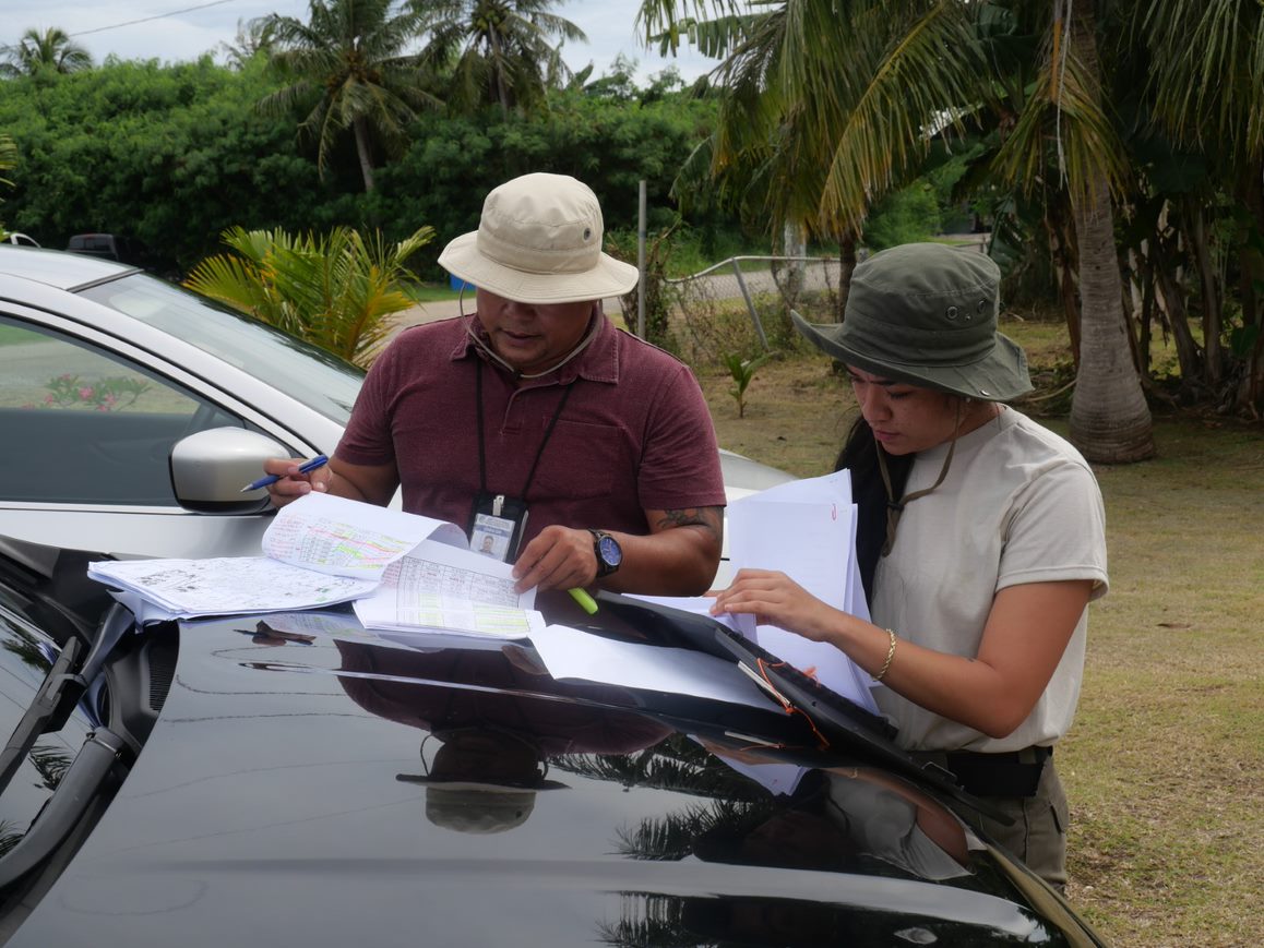 IRP Anthropologist Keona DLG Torres and NMHC DR Loan Specialist Melvin Sablan review a list of NMHC Home sites to be surveyed.