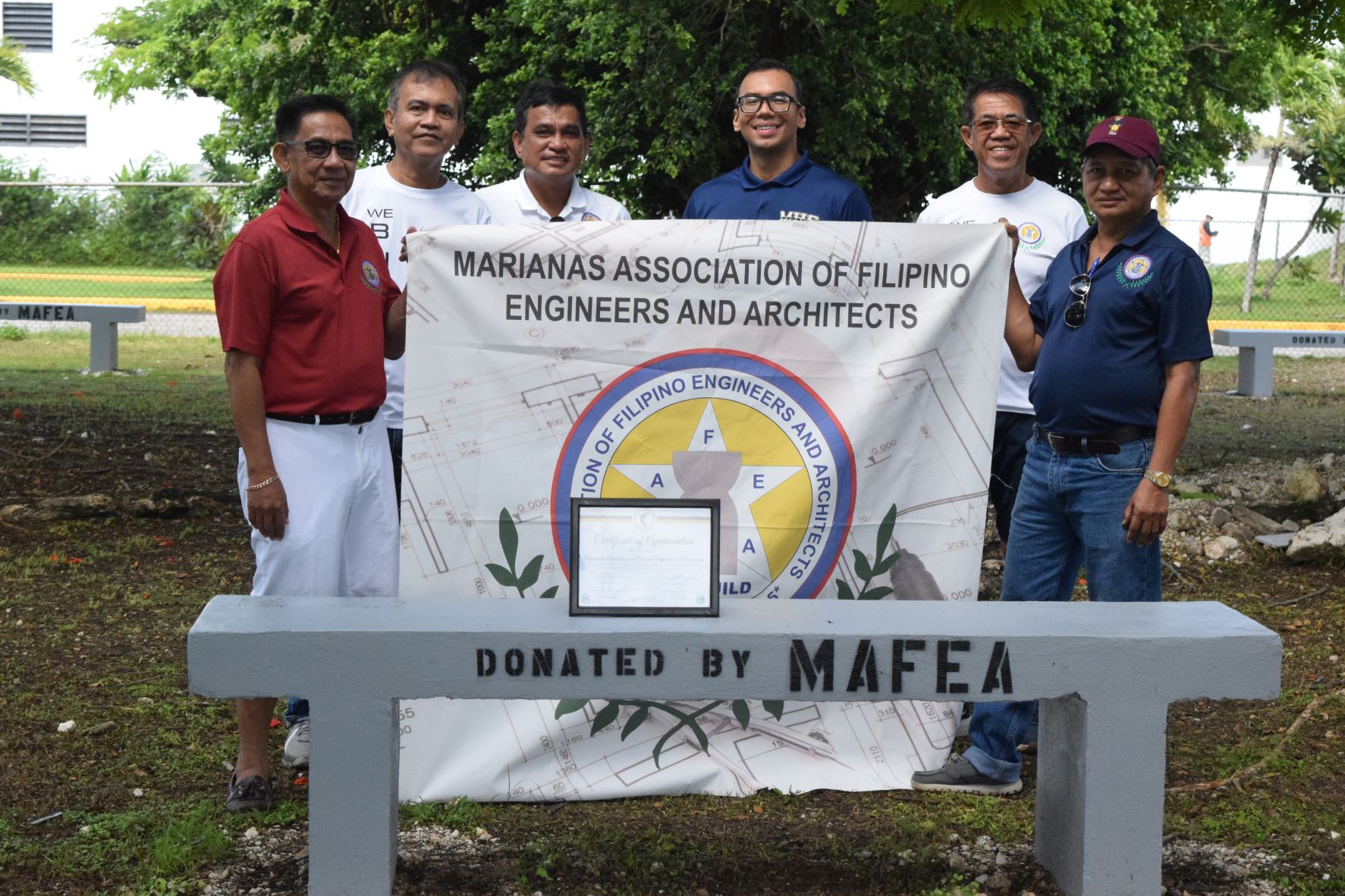 Marianas Association of Filipino Engineers and Architects President Ariel Villanueva, third left, Marianas High School Principal Jonathan Aguon, M. Ed. center, and other MAFEA members, from left, Rick Ansay, Hector Sevilla, MAFEA Vice President Jojo Saracho and Merly Mago pose for a photo behind one of the newly built benches at MHS on Saturday.Photo by Emmanuel T. Erediano