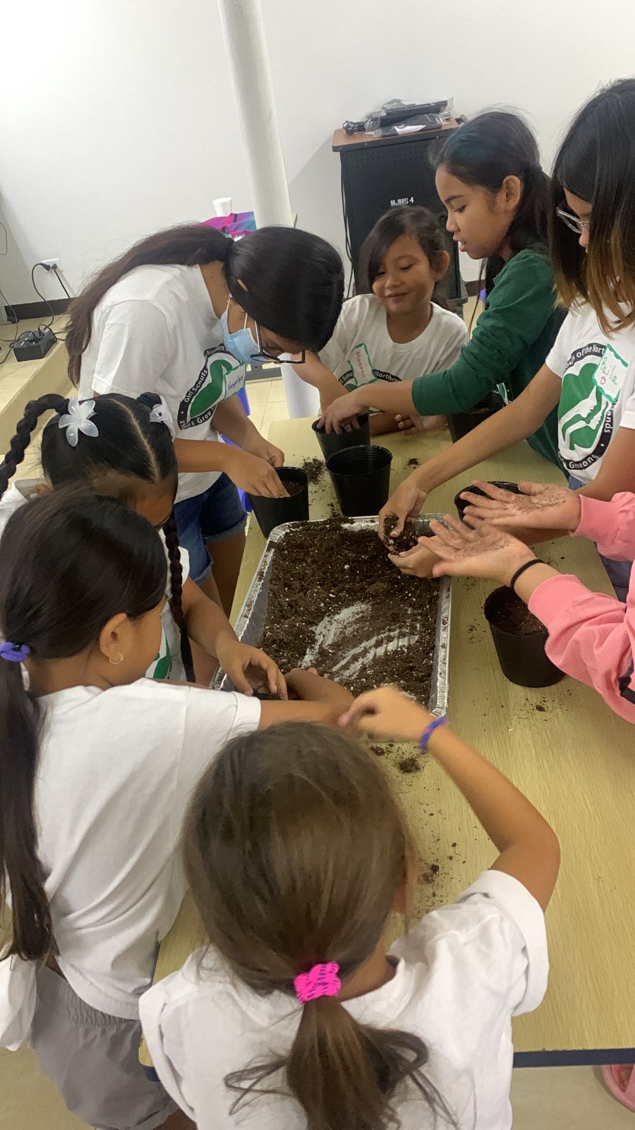 NMI Girl Scouts learn how to measure soil for their seedlings during a workshop Saturday at Hopwood Jr. High School as part of earning a badge.
