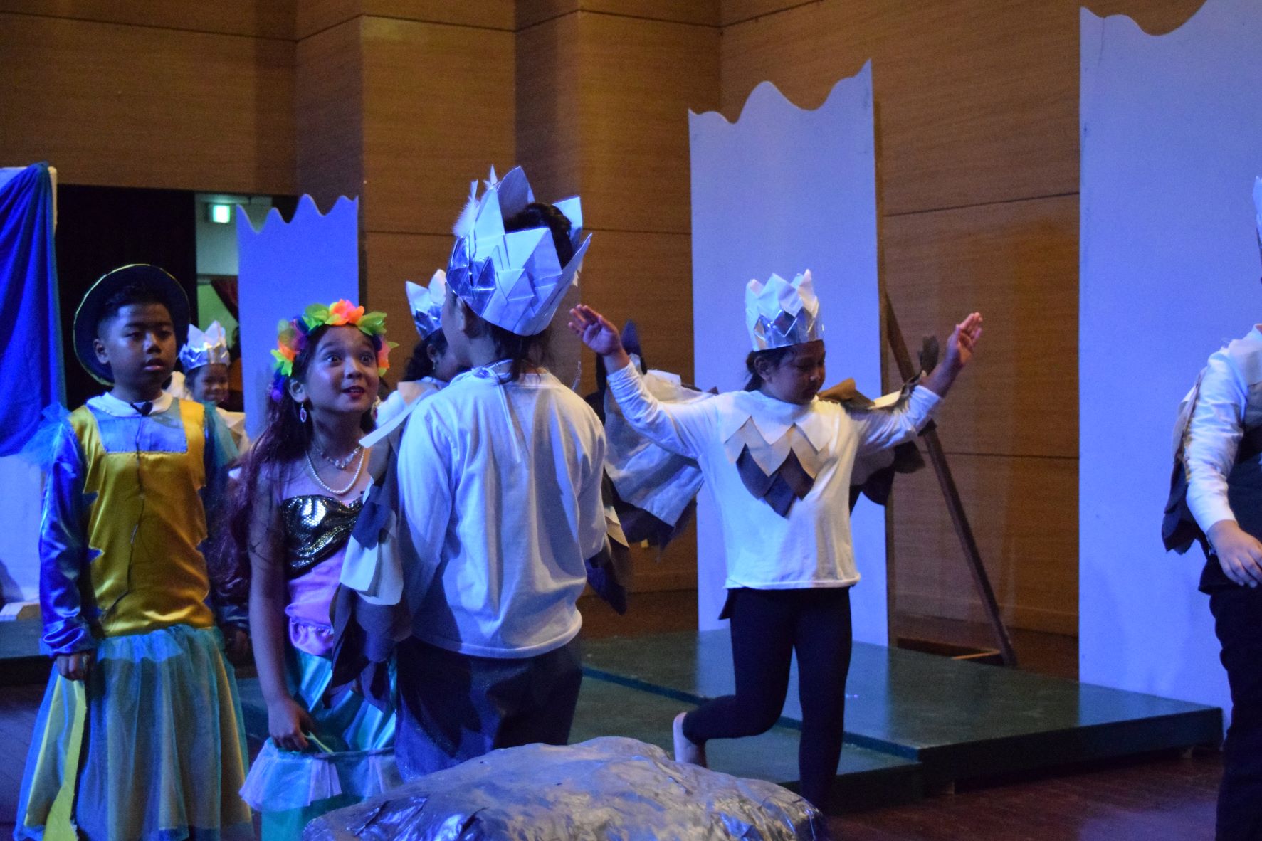 Ariel, talks to Scuttle, Juliana Keri Ortiz, while Flounder Benjie Escano stands next to her and the sea gulls  fly by.