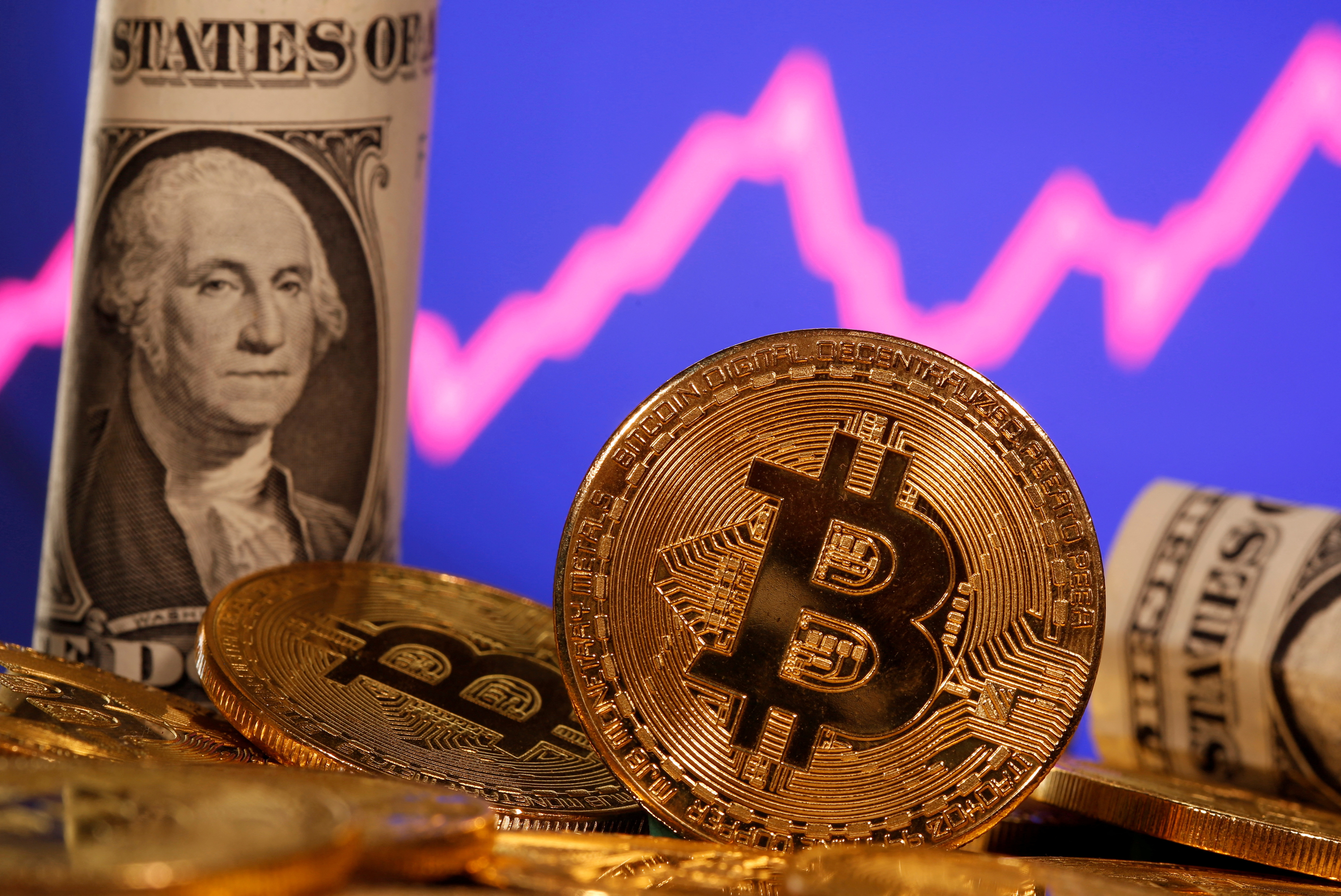 A representation of virtual currency bitcoin and a U.S. one dollar banknote are seen in front of a stock graph in this illustration taken Jan. 8, 2021.