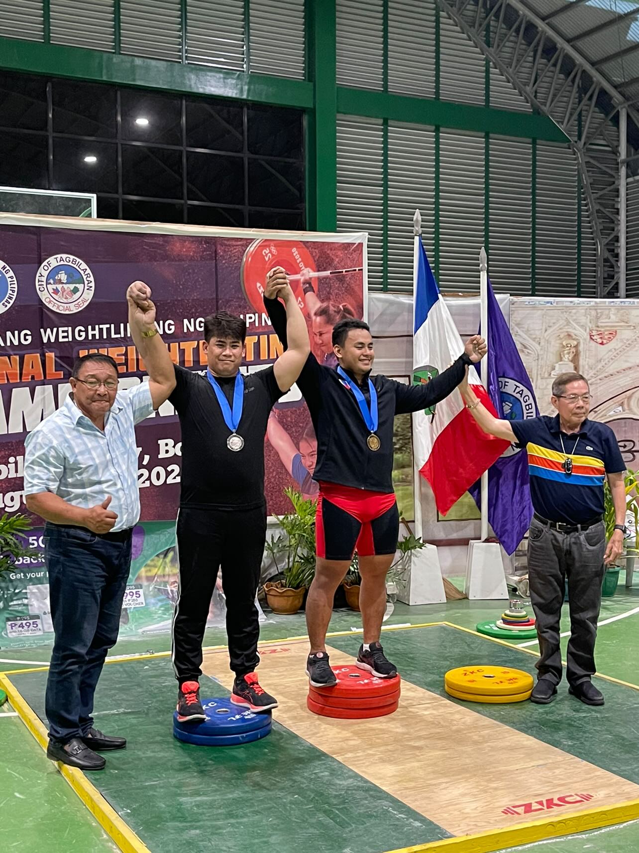 Angel San Nicolas, second left, wins a silver medal in the Philippine national weightlifting competition in Tagbilaran, Bohol, the central Philippines. The event was held from Aug. 8 to 12, 2022.