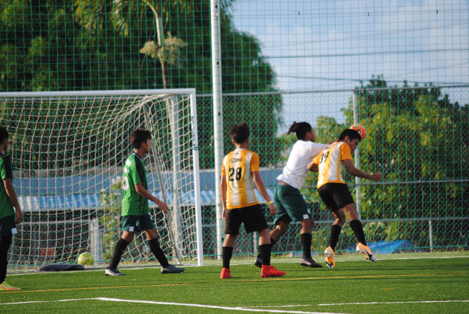 Kanoa's Leland Deleon Guerrero attempts the header for the goal as Tan Holdings goalkeeper Terell Hix reaches in for the save.