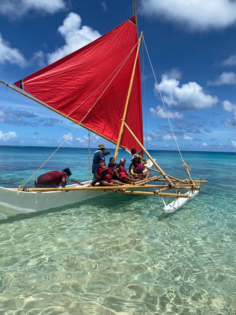 Sanjo Maras, Andrew Roberto, and Uirom Park take Camp Maga'lahi students on a ride around the waters of Tachogna.