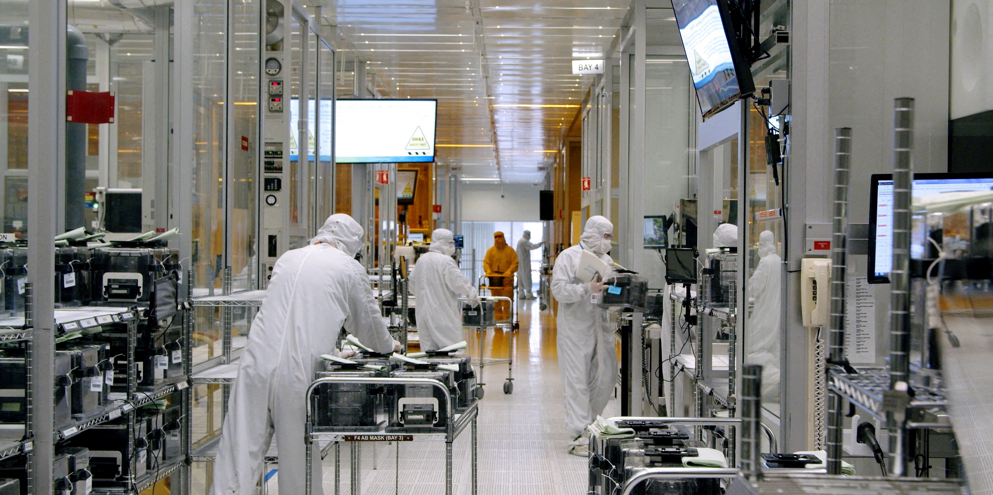 Workers are seen inside the clean room of U.S. semiconductor manufacturer SkyWater Technology Inc where computer chips are made, in Bloomington, Minnesota,  April 2022.