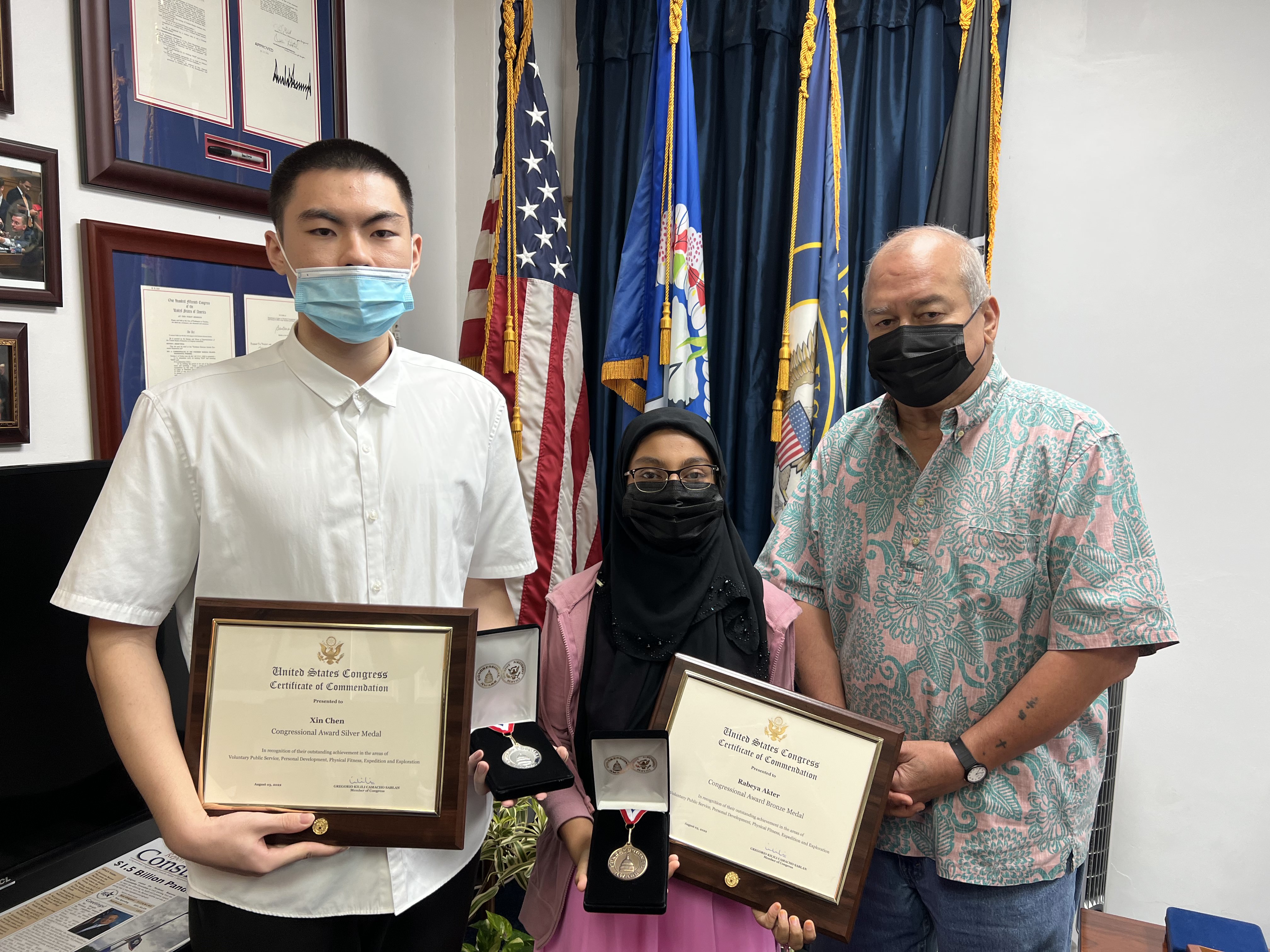 U.S. Congressman Gregorio Kilili Camacho Sablan presents Rabeya Akter and Steven Chen with congressional commendations for being the first individuals from the Northern Marianas to achieve the Congressional Award. 