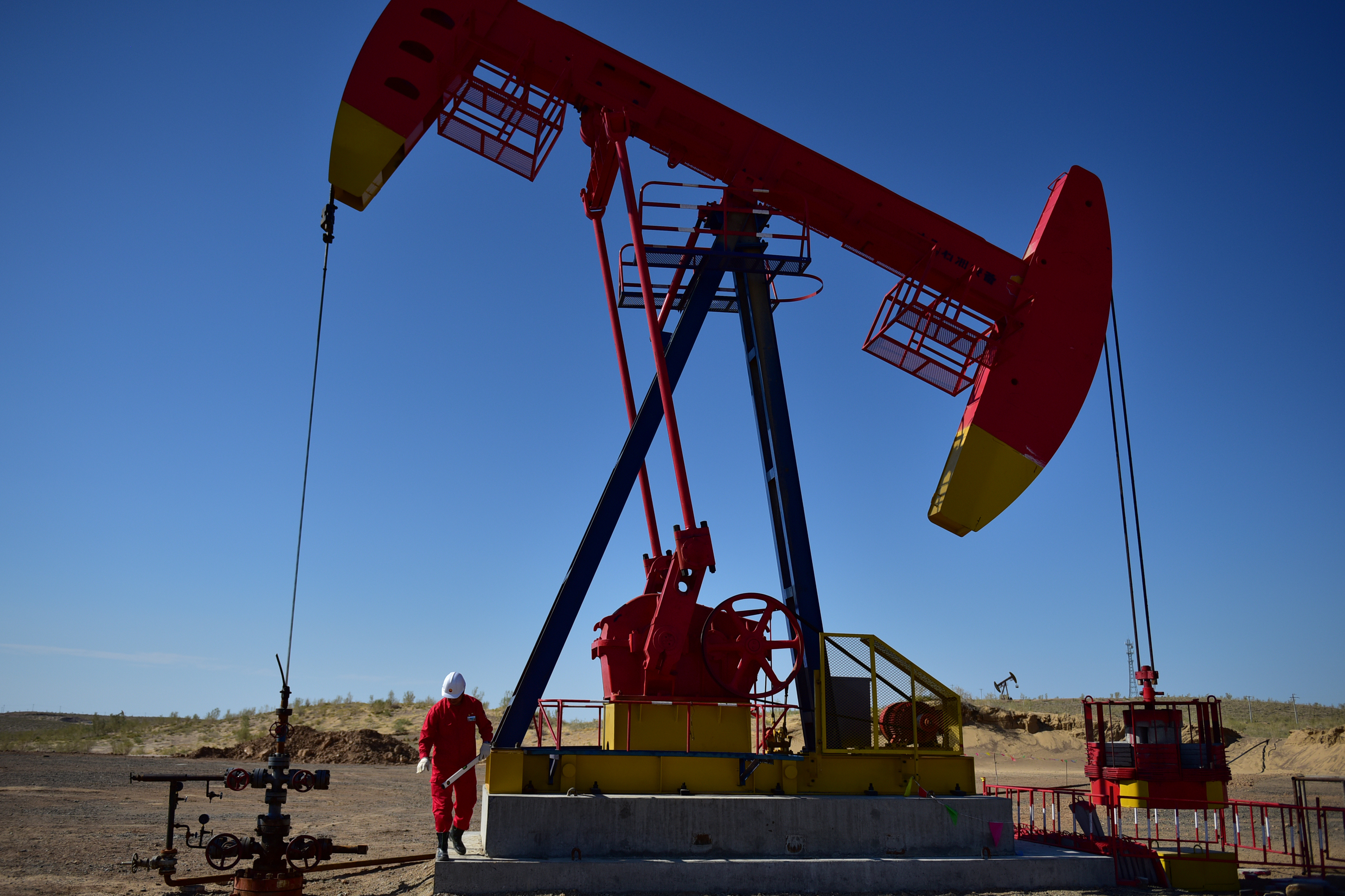 A PetroChina worker inspects a pump jack at an oil field in Tacheng, Xinjiang Uighur Autonomous Region, China on June 27, 2018.