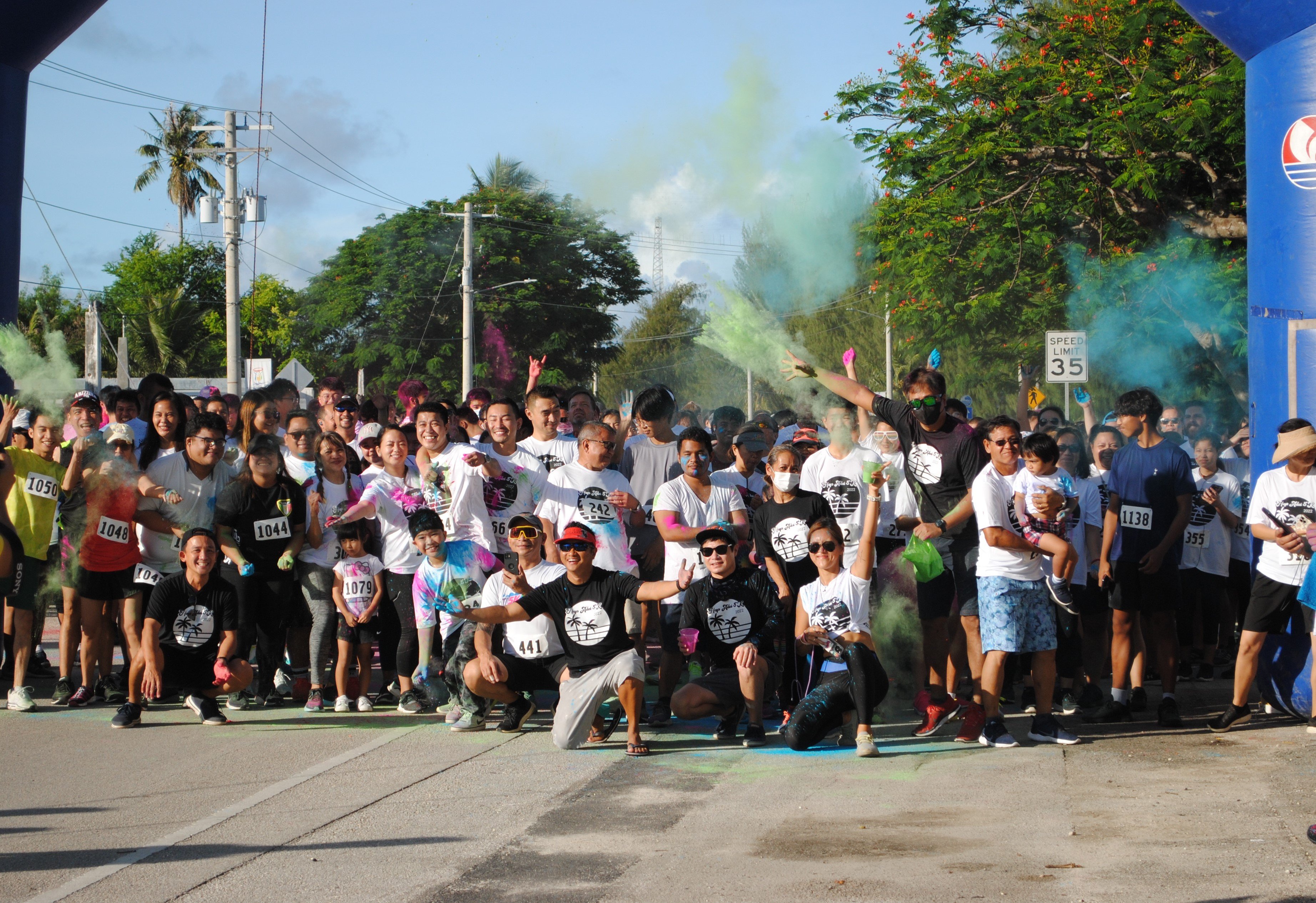 Pacific Islands Club Saipan General Manager Dennis Seo, center, poses for a photo with the participants before the start of the PIC Hafa Adai 5K Color Run on Saturday.