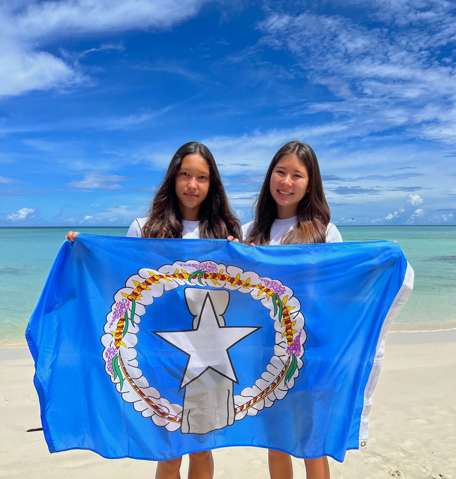 Local swimmers Savita Sikkel and Jinie Thompson pose for a photo while displaying the CNMI flag. They have been selected to compete in the Eighth World Junior Swimming Championships in Lima, Peru from Aug. 30 to Sept. 5.
