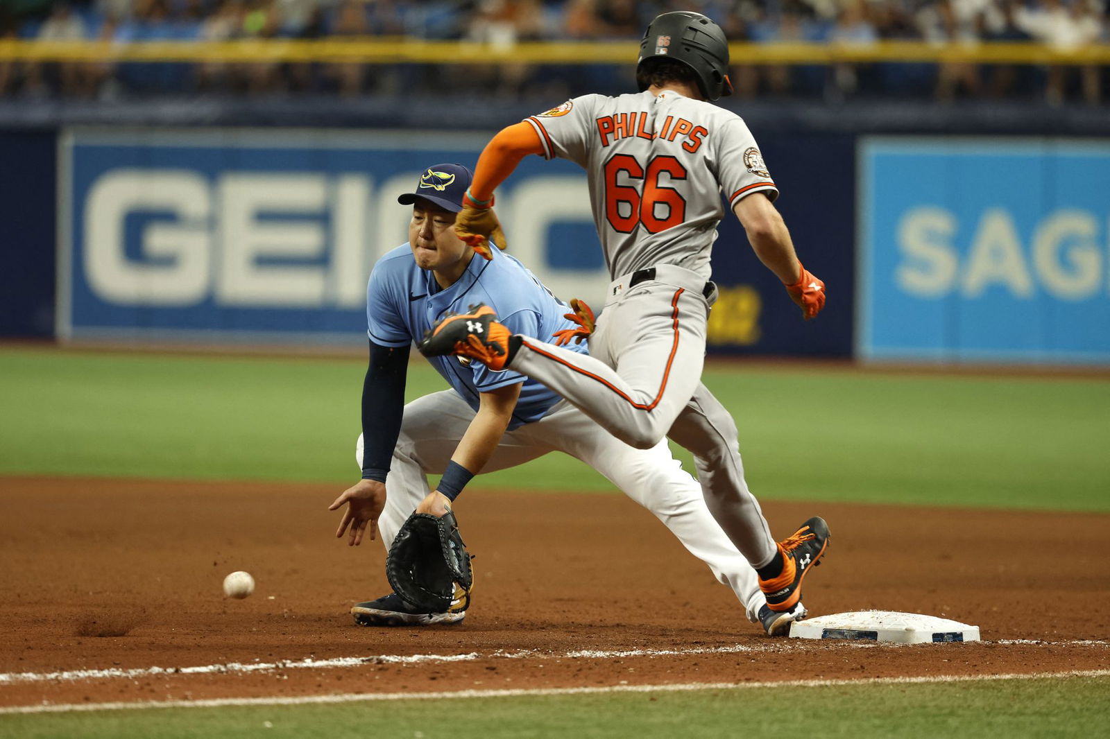 Baltimore Orioles center fielder Brett Phillips (66) is safe at first base as Tampa Bay Rays first baseman Ji-Man Choi (26) attempted to force him out during the ninth inning at Tropicana Field in St. Petersburg, Florida, Aug. 14, 2022.