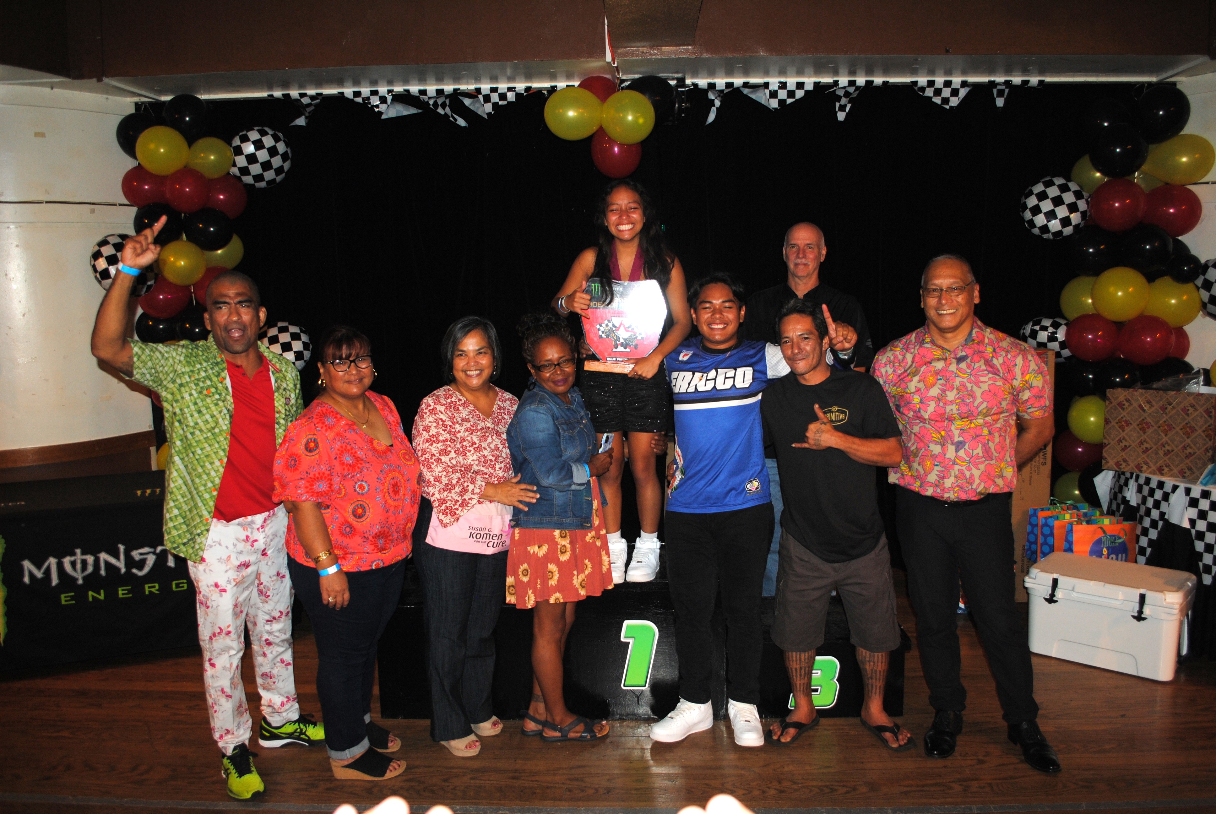 Billie Pangelinan smiles as she holds the Power Puff Class red plate trophy while posing for a photo with her family and Marianas Racing Association officials during the awards ceremony on Saturday at PIC.