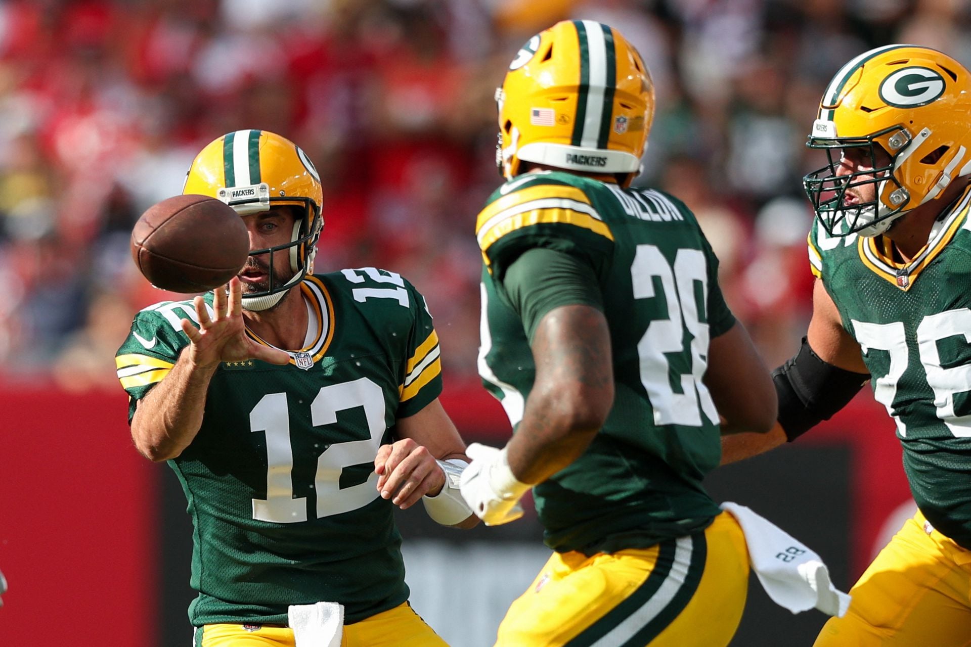 Green Bay Packers quarterback Aaron Rodgers (12) shuffles a pass to running back AJ Dillon (28) against the Tampa Bay Buccaneers in the second quarter at Raymond James Stadium in Tampa, Florida, Sept. 25, 2022.