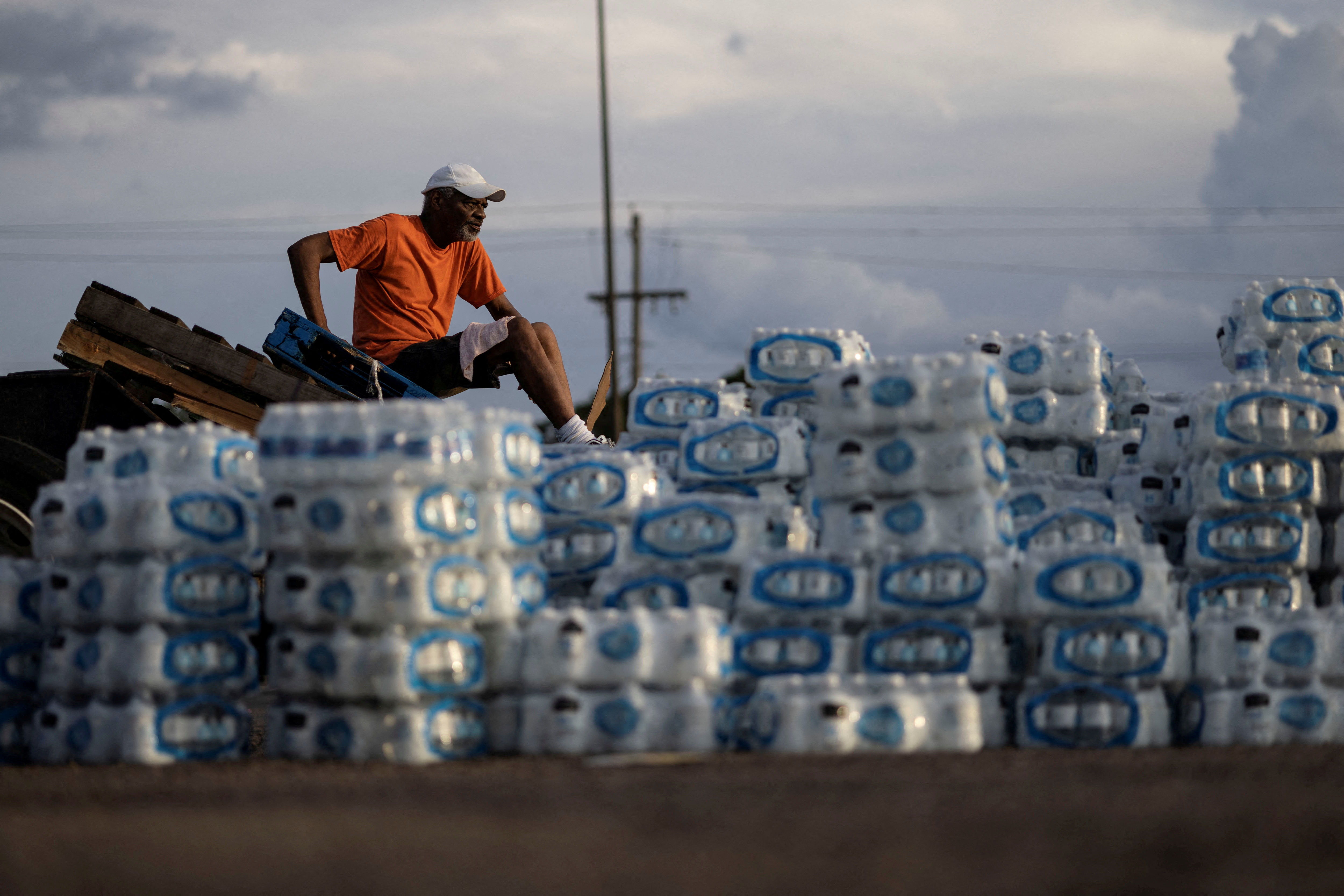 Phillip Young, a local resident from Jackson, Mississippi, takes a break while helping local volunteers with the distribution of bottles of water as city of Jackson and areas around are to go without reliable drinking water indefinitely after pumps at the water treatment plant failed, leading to the emergency distribution of bottled water and tanker trucks for 180,000 people, in Jackson, Mississippi, Aug. 31, 2022.