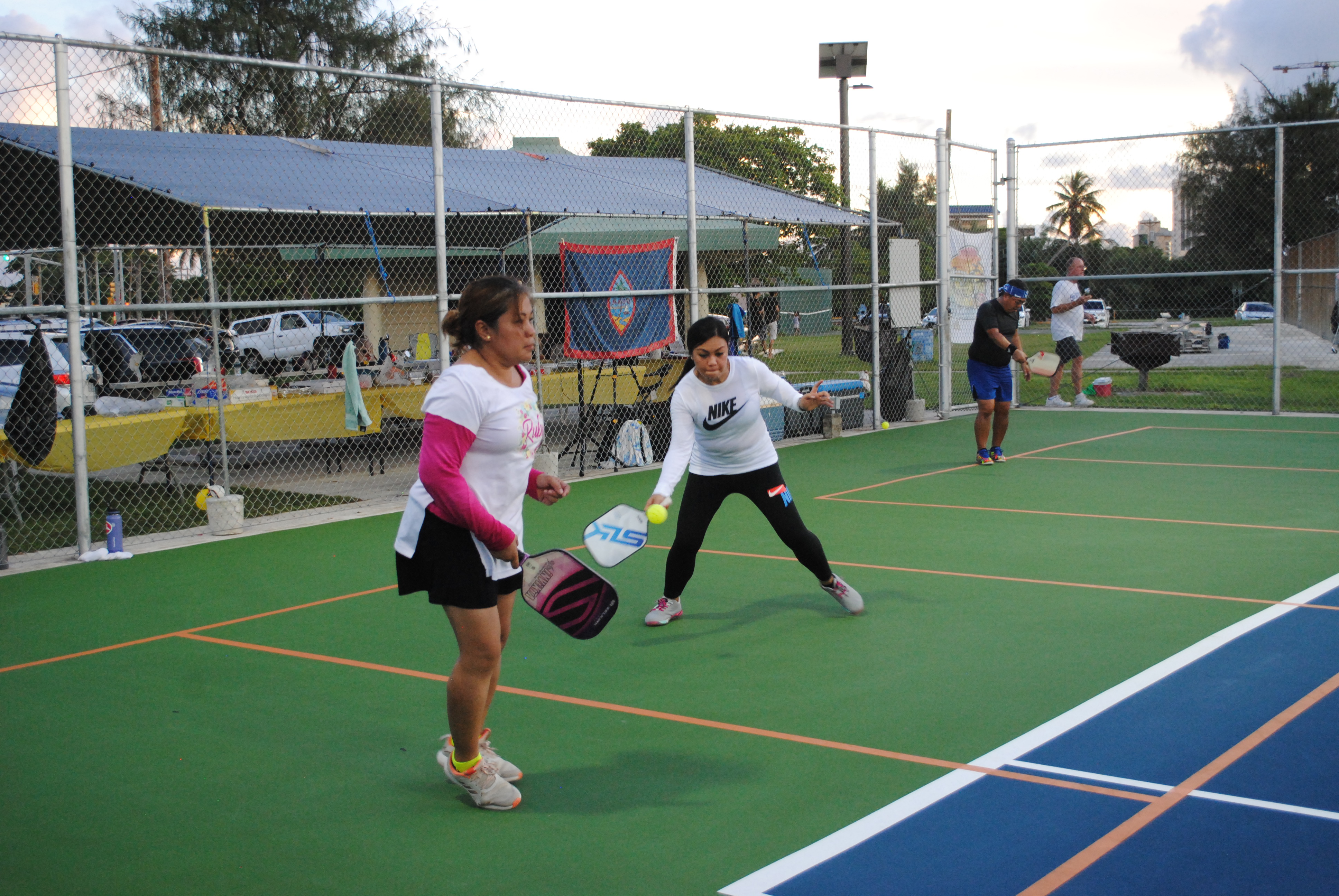 Miles Guerrero extends for the return as her teammate looks on.